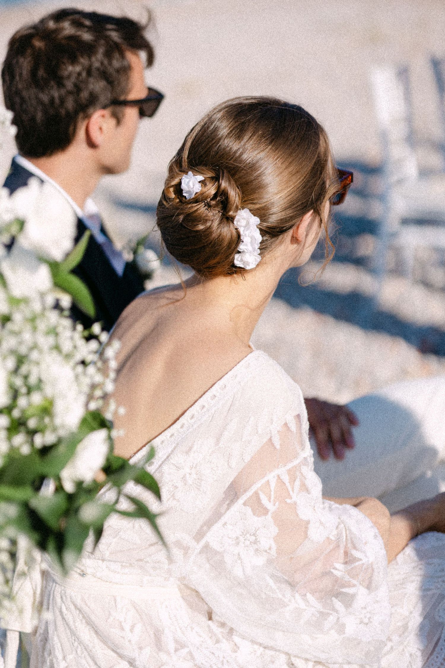 a photo of bride and groom with their backs on the camera sitting in chairs