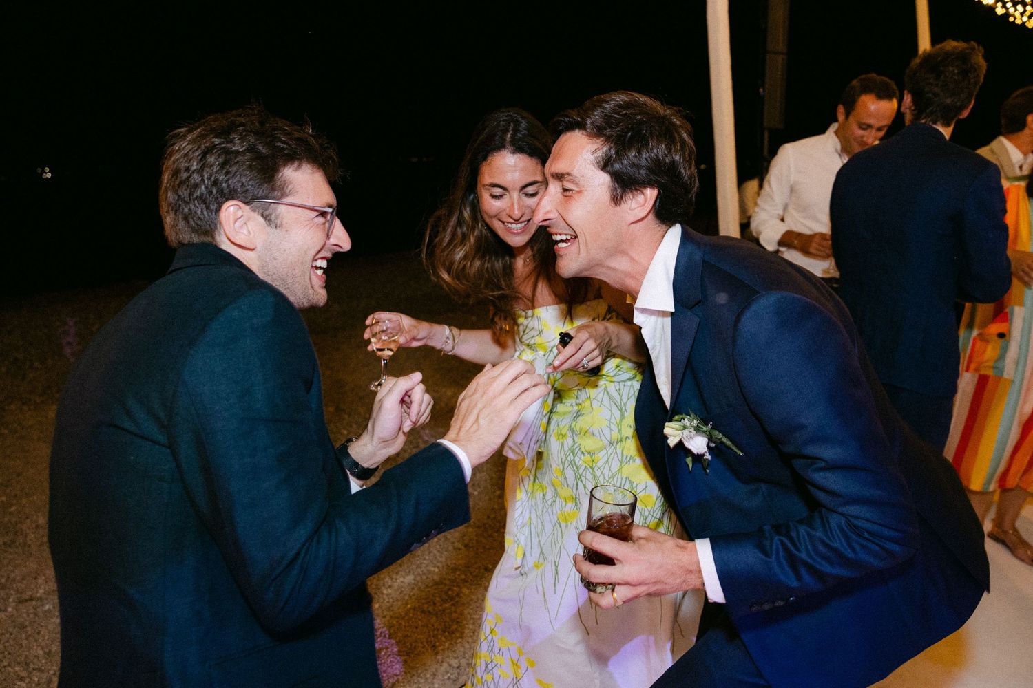 three wedding guests singing loud and dancing at night