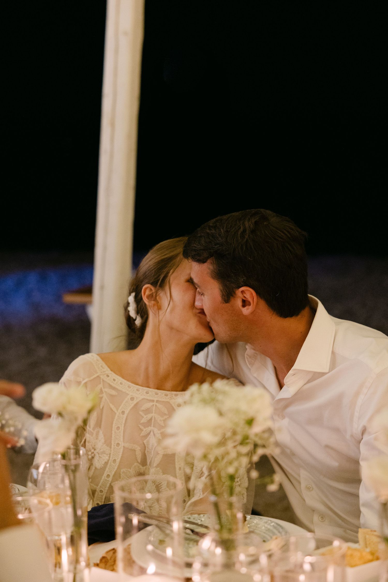 a crying bride kissing her husband on their wedding table
