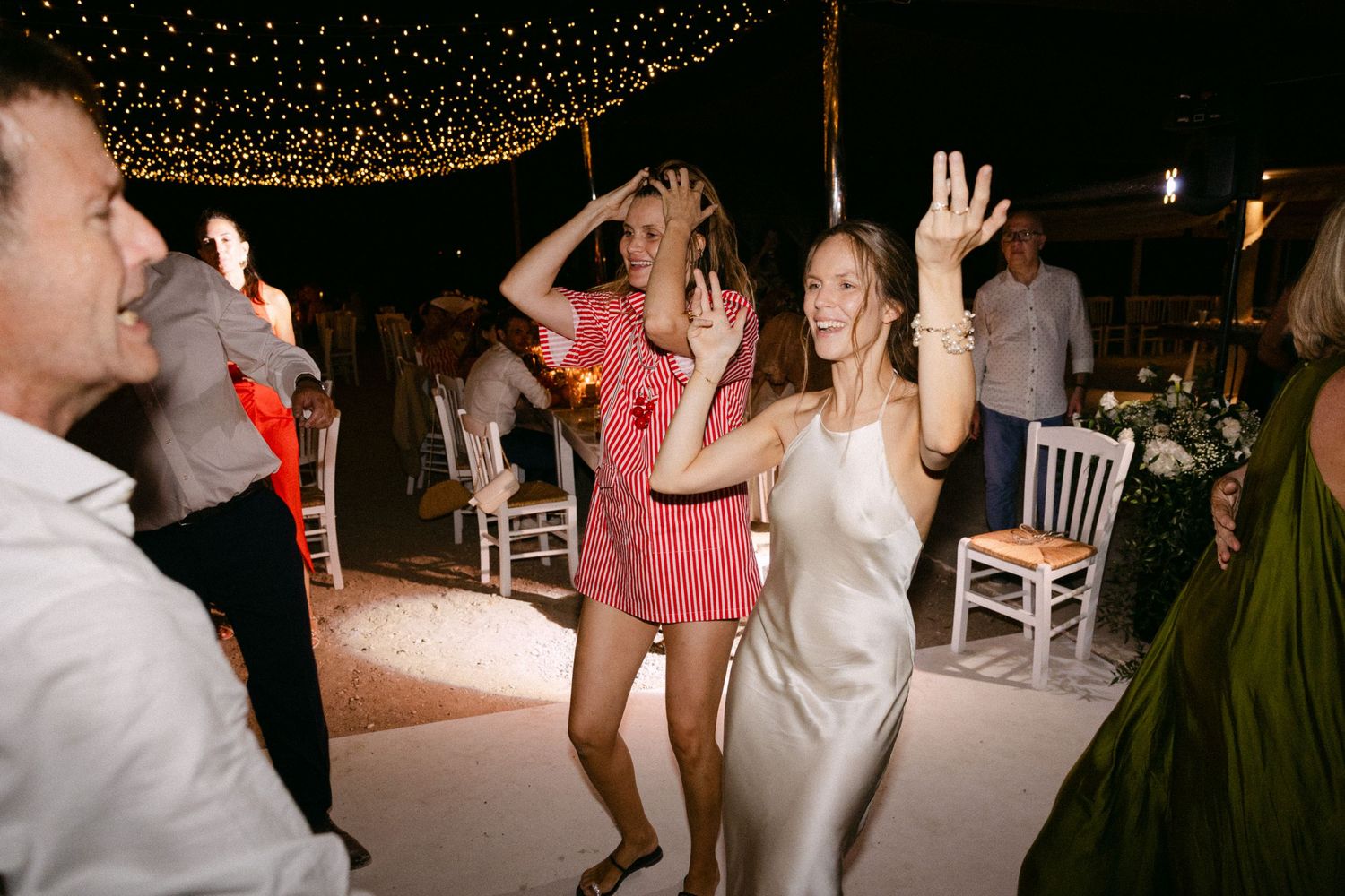 a bride and guests dancing during the open-air wedding party of their Spetses wedding, smiling