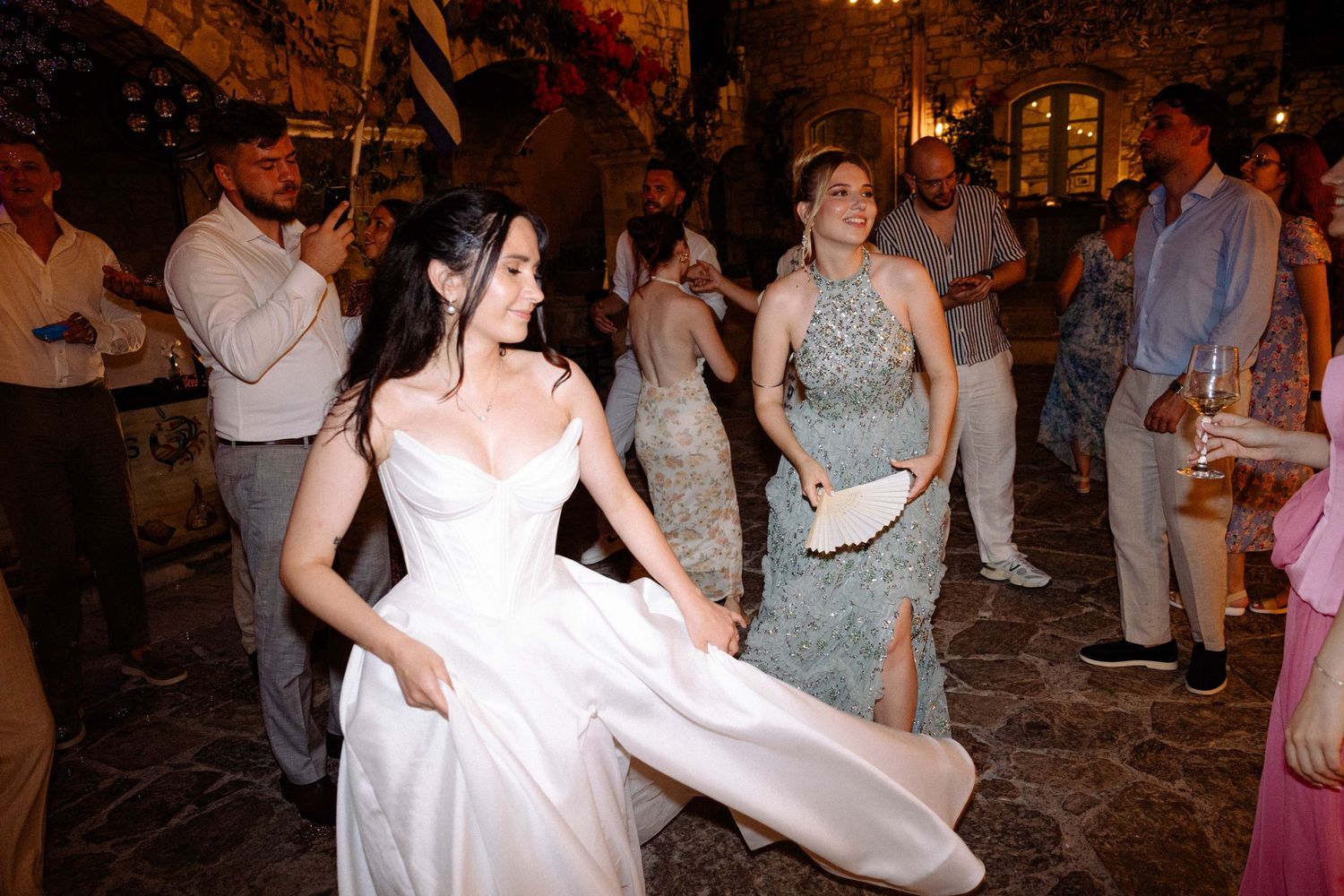 a bride twirling in her white wedding dress in an outdoors wedding reception in Crete