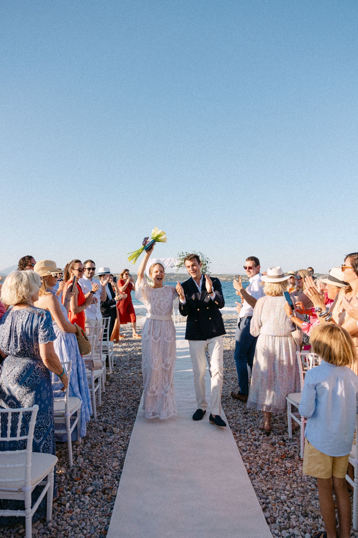 a bride and groom exiting their open-air beach wedding ceremony in Spetses, Greece