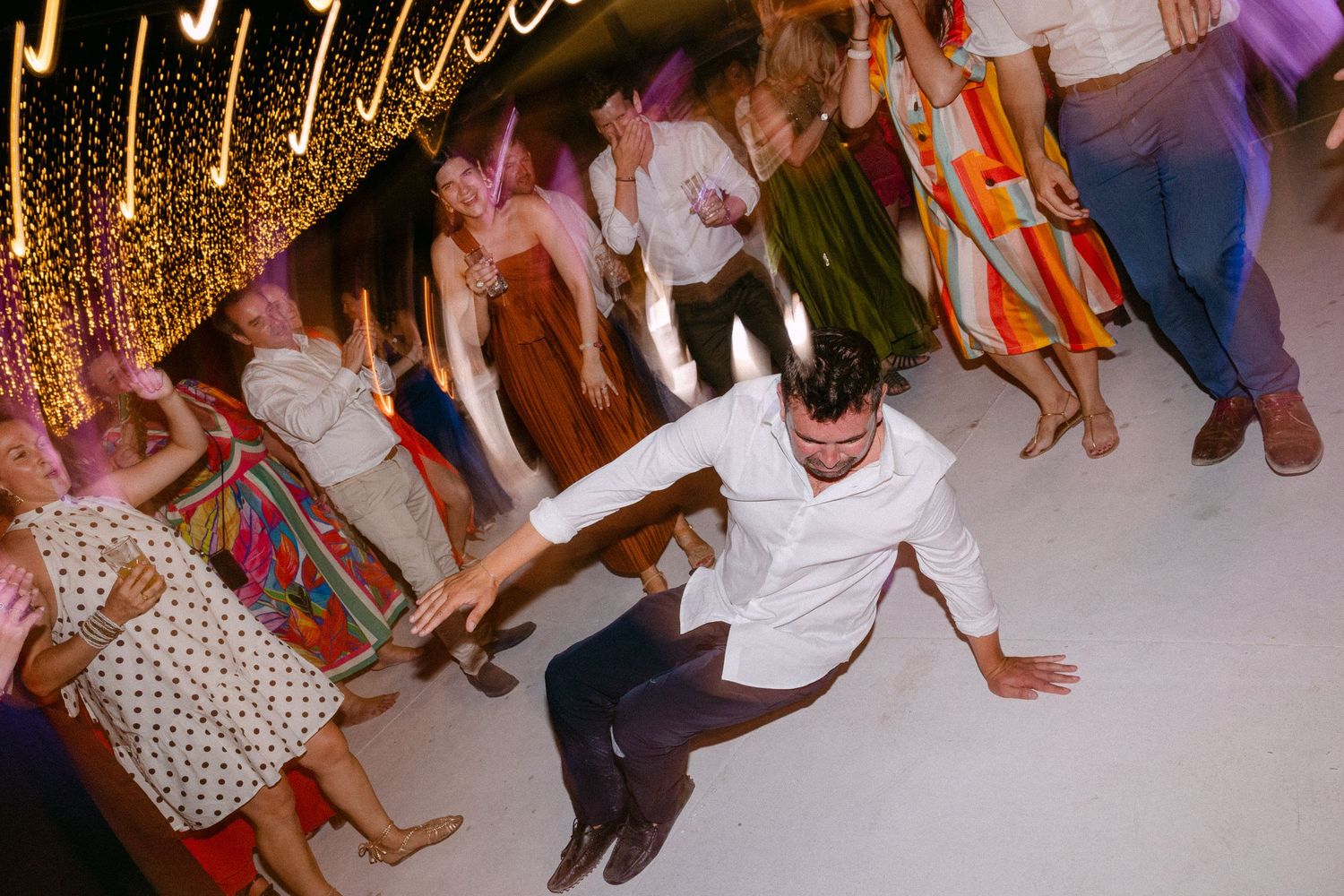 a man break-dancing among wedding guests as they are cheering