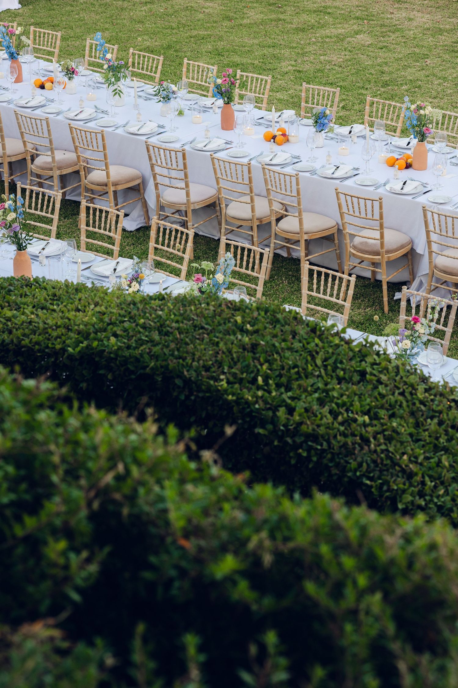 table set up of two tables with colorful wedding flowers and fruits decorations