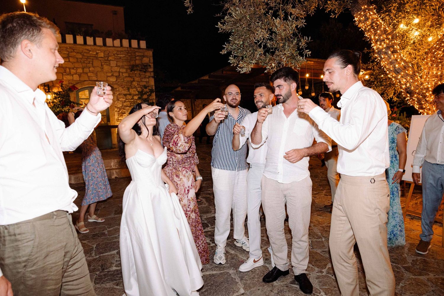 newlyweds and their guests drinking shots in a night outdoor setting at agreco farms