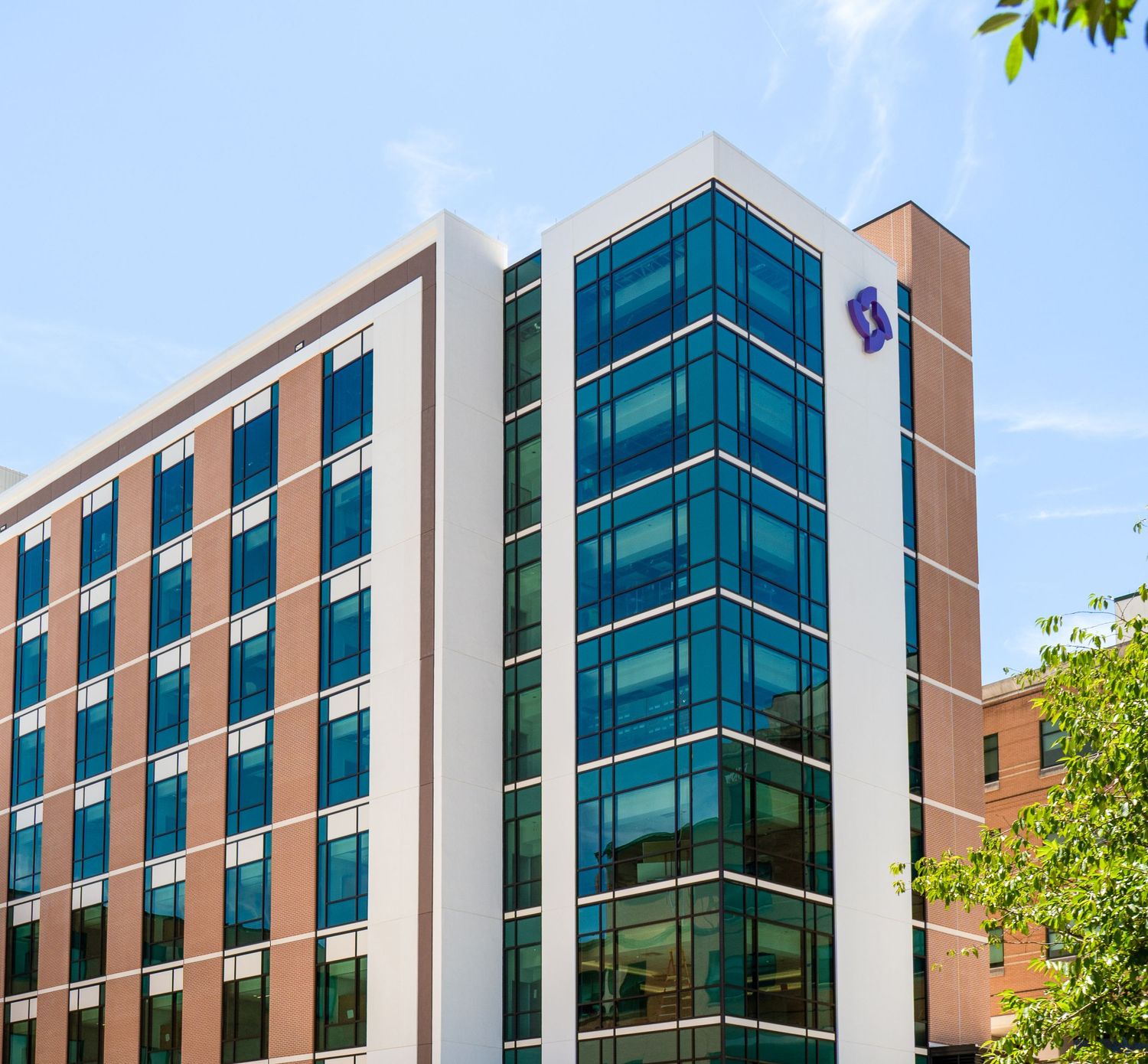 Modern office building exterior with glass windows and geometric architecture.