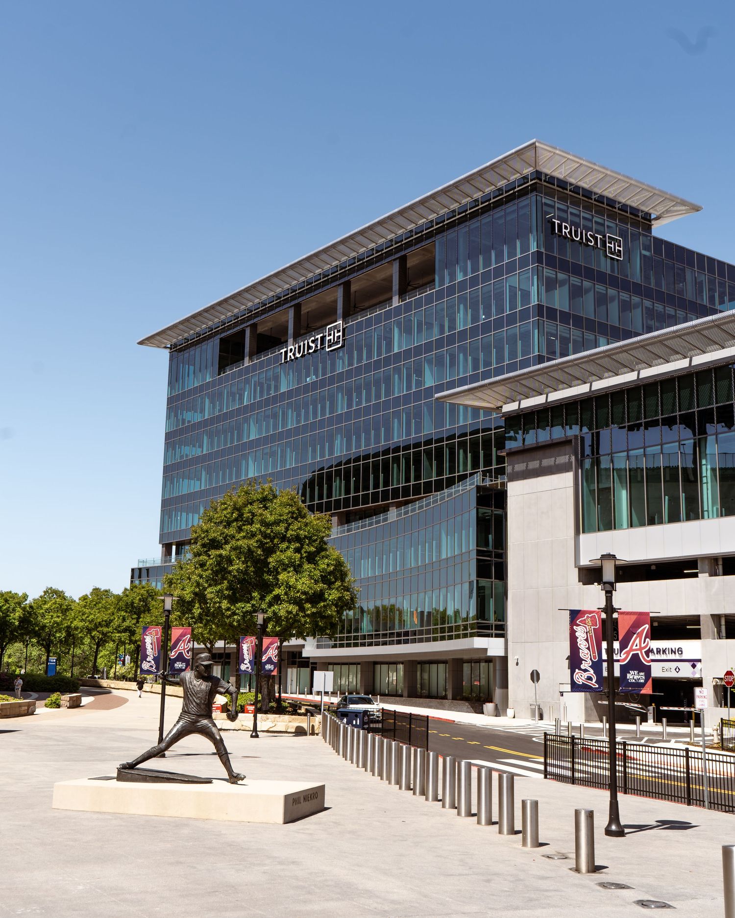Modern glass office building complex with angular architecture and outdoor walkways shown from different perspectives.