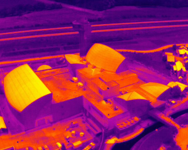 Thermal imaging scan showing heat patterns in orange and purple tones across building structure.
