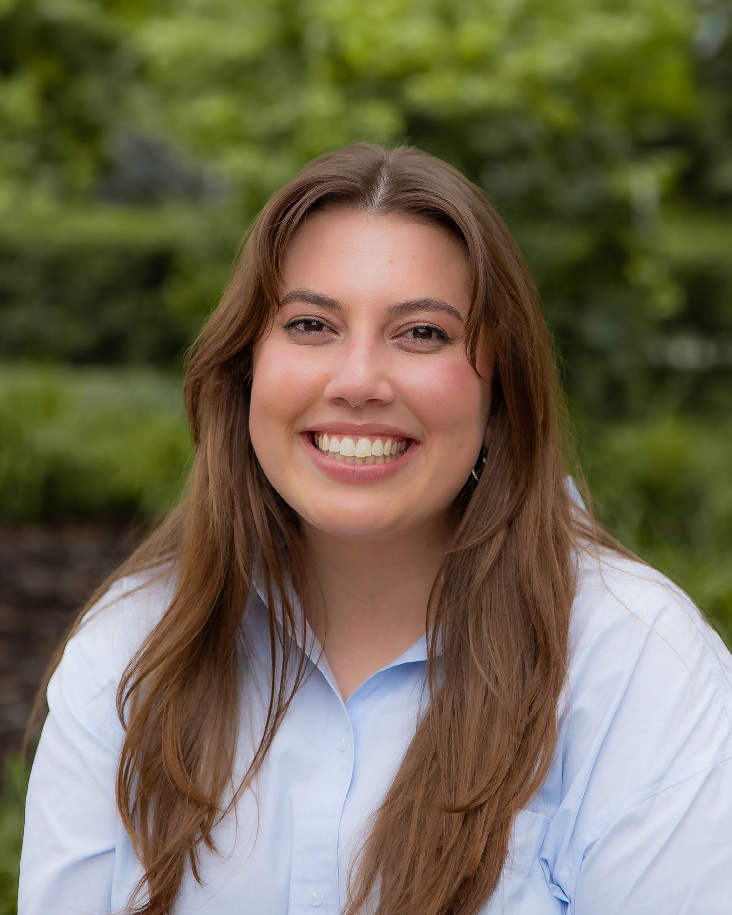 Professional headshot series showing warm expressions in an outdoor setting with natural lighting and white blouse.