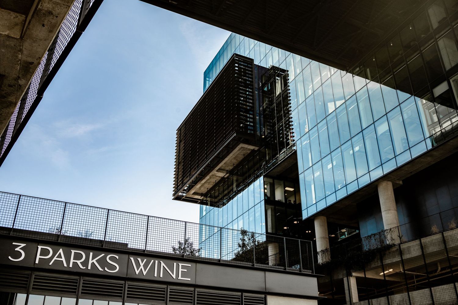 Contemporary glass office buildings with modern architectural details viewed from below.