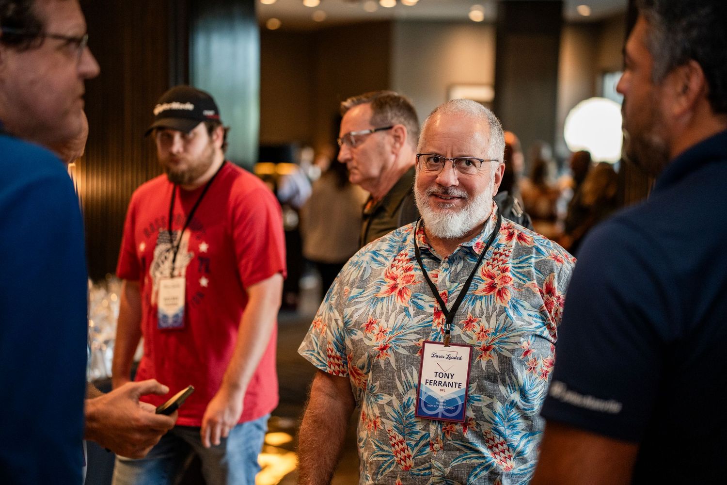 A group of people socialize and network at an indoor business event or conference.