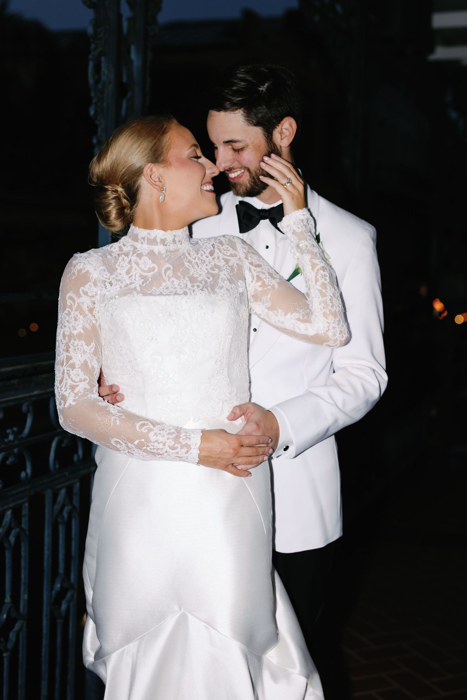 Romantic nighttime dance between newlyweds in formal wedding attire.