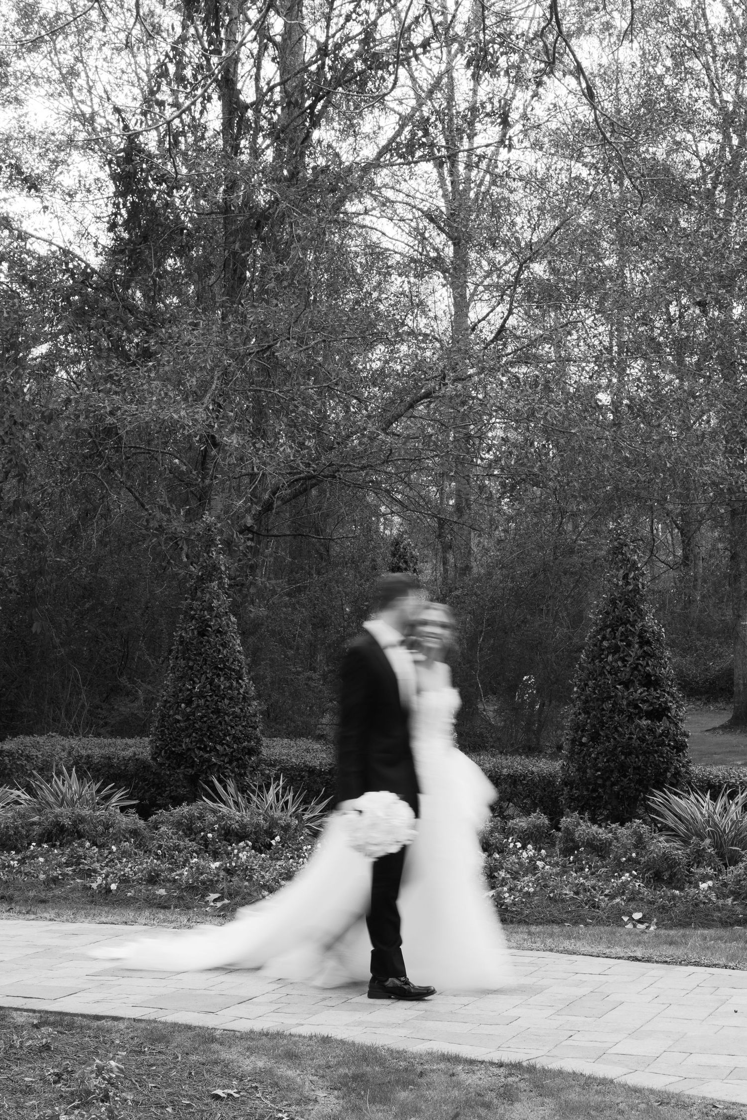 A series of black and white photos showing a couple dancing in a garden setting with blurred motion effects.