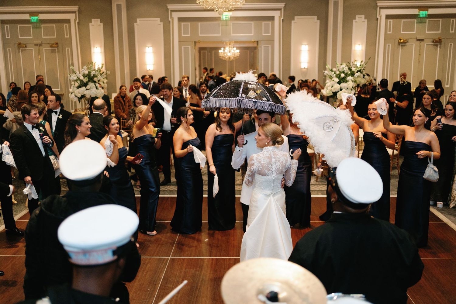 Wedding reception dance floor filled with guests in formal attire and military dress uniforms.
