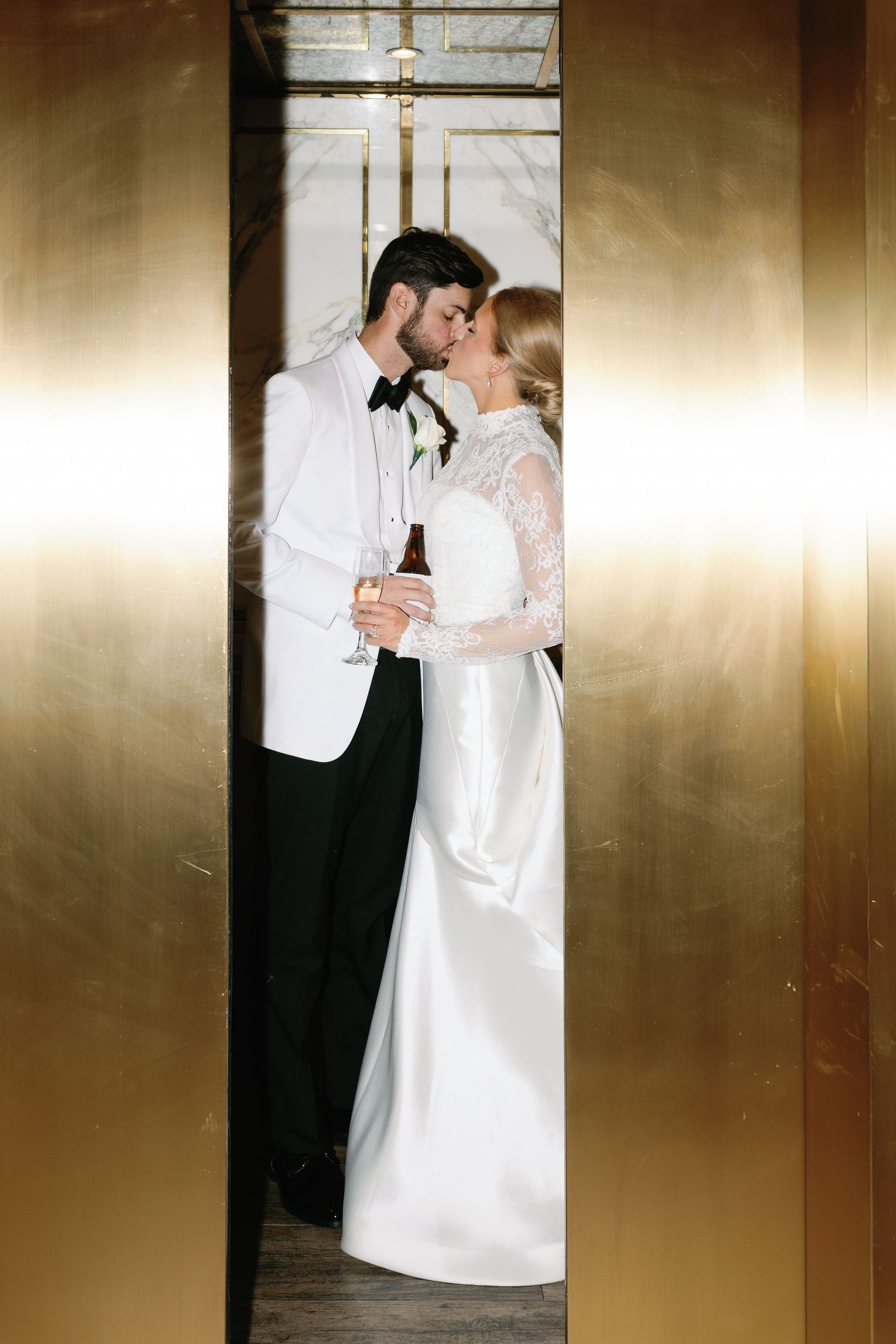 Intimate wedding portraits against a golden metallic backdrop create dramatic lighting effects.