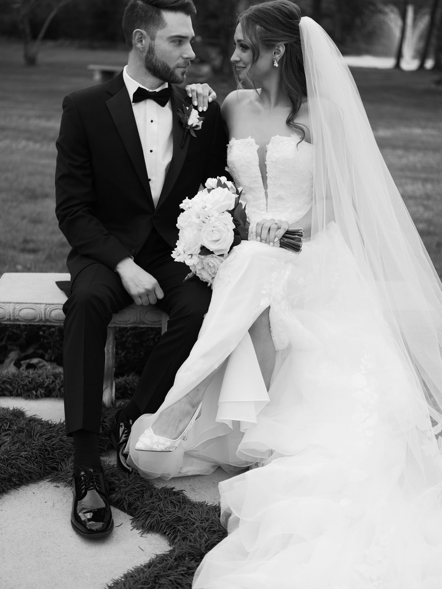 Black and white wedding photos capturing intimate moments between newlyweds in garden setting.