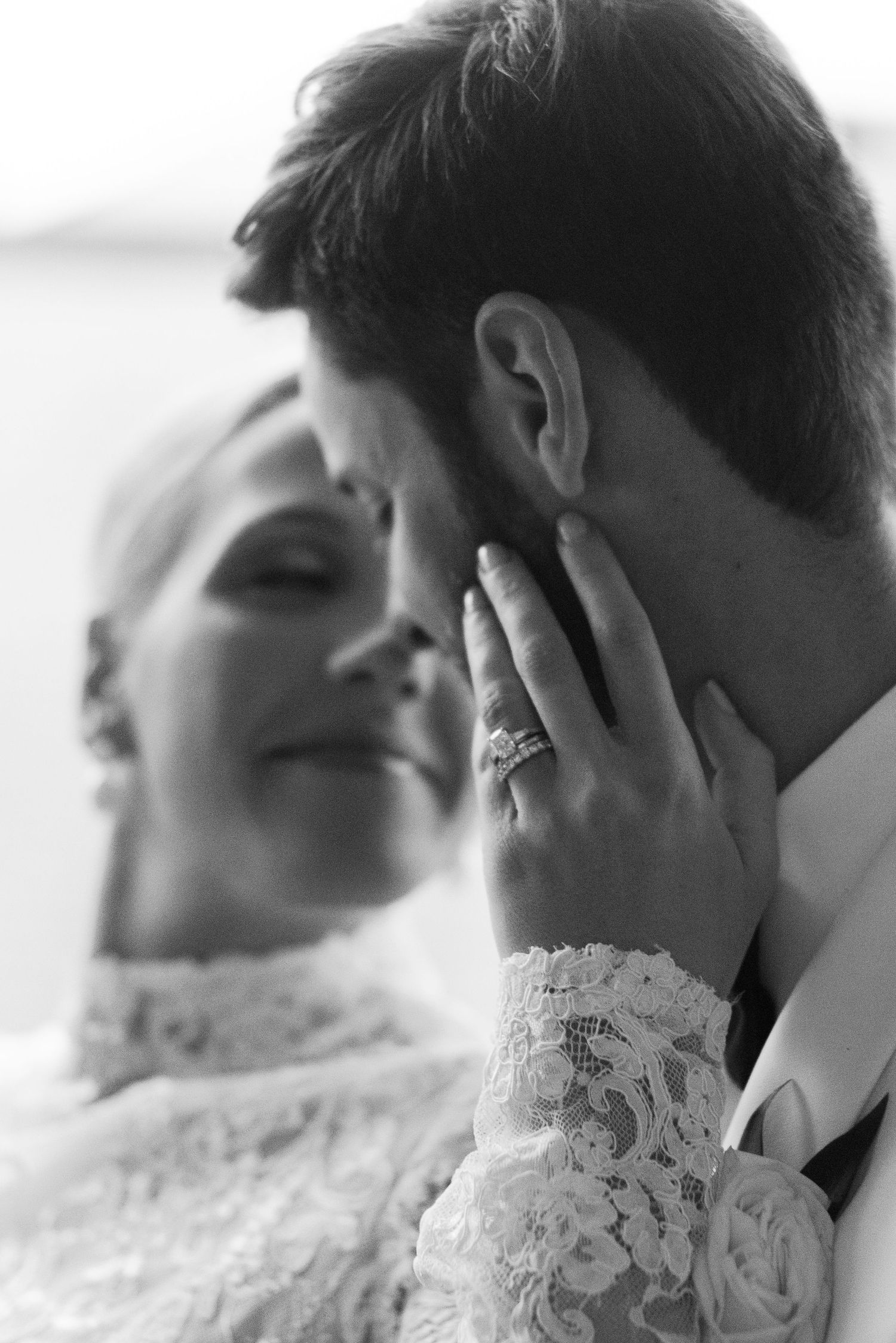 Intimate black and white close-up of romantic wedding moment.