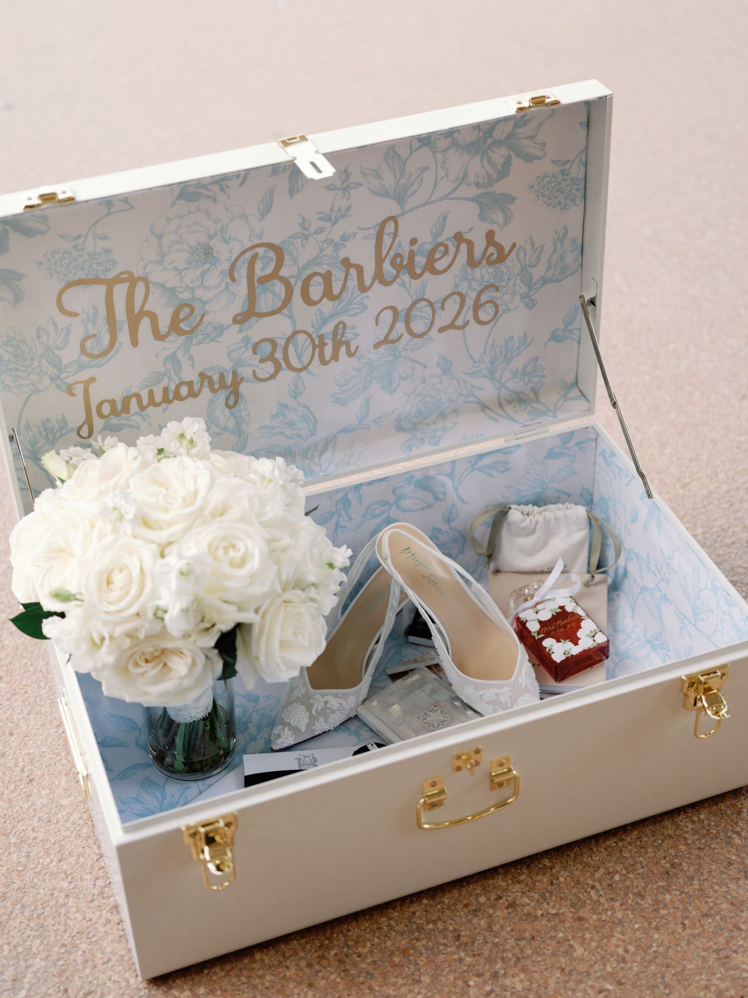 Decorative white keepsake box containing roses, wedding shoes and accessories with personalized text.