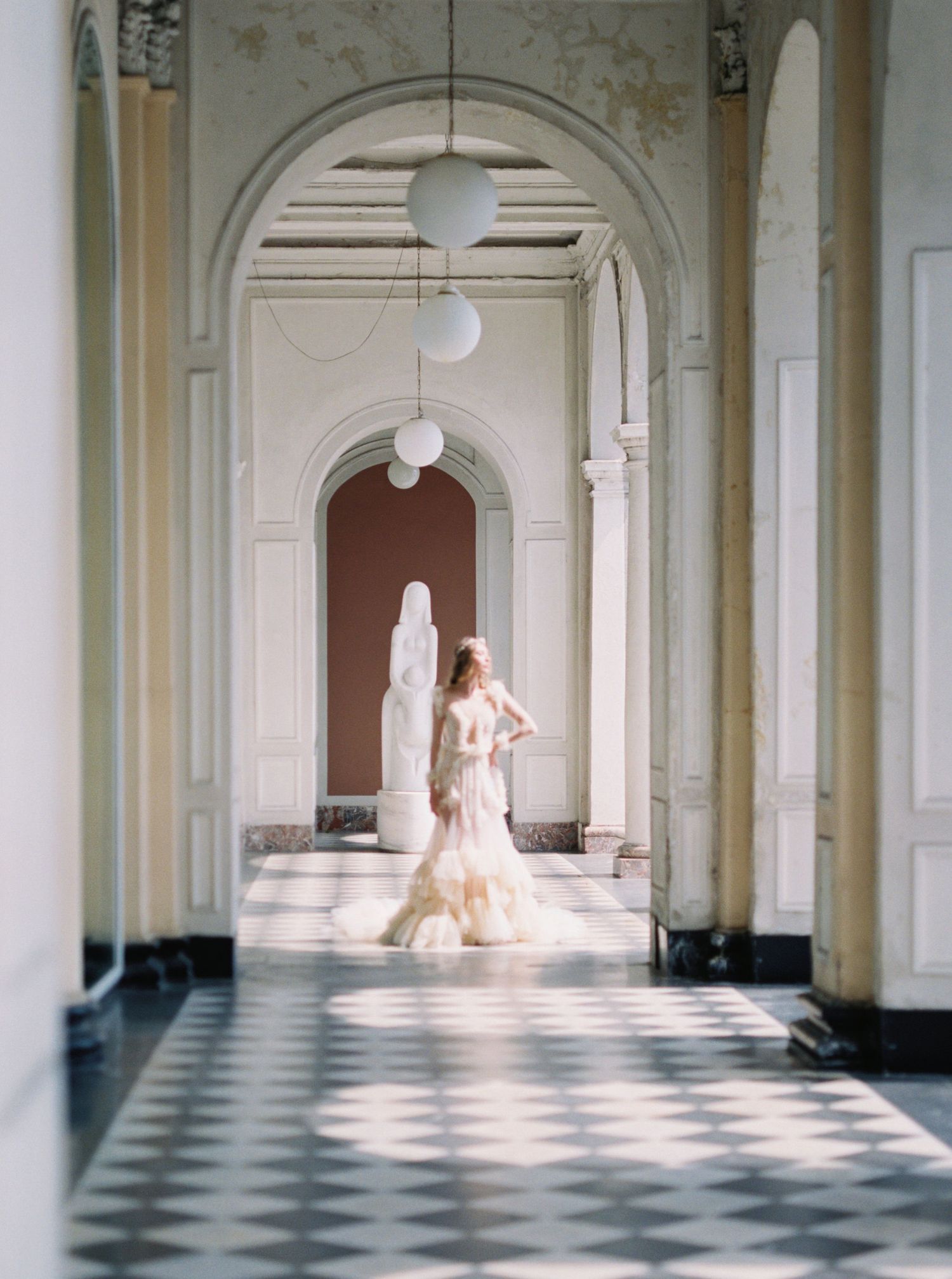 Ethereal bridal portraits in grand hallway with checkered floors and classical arches.