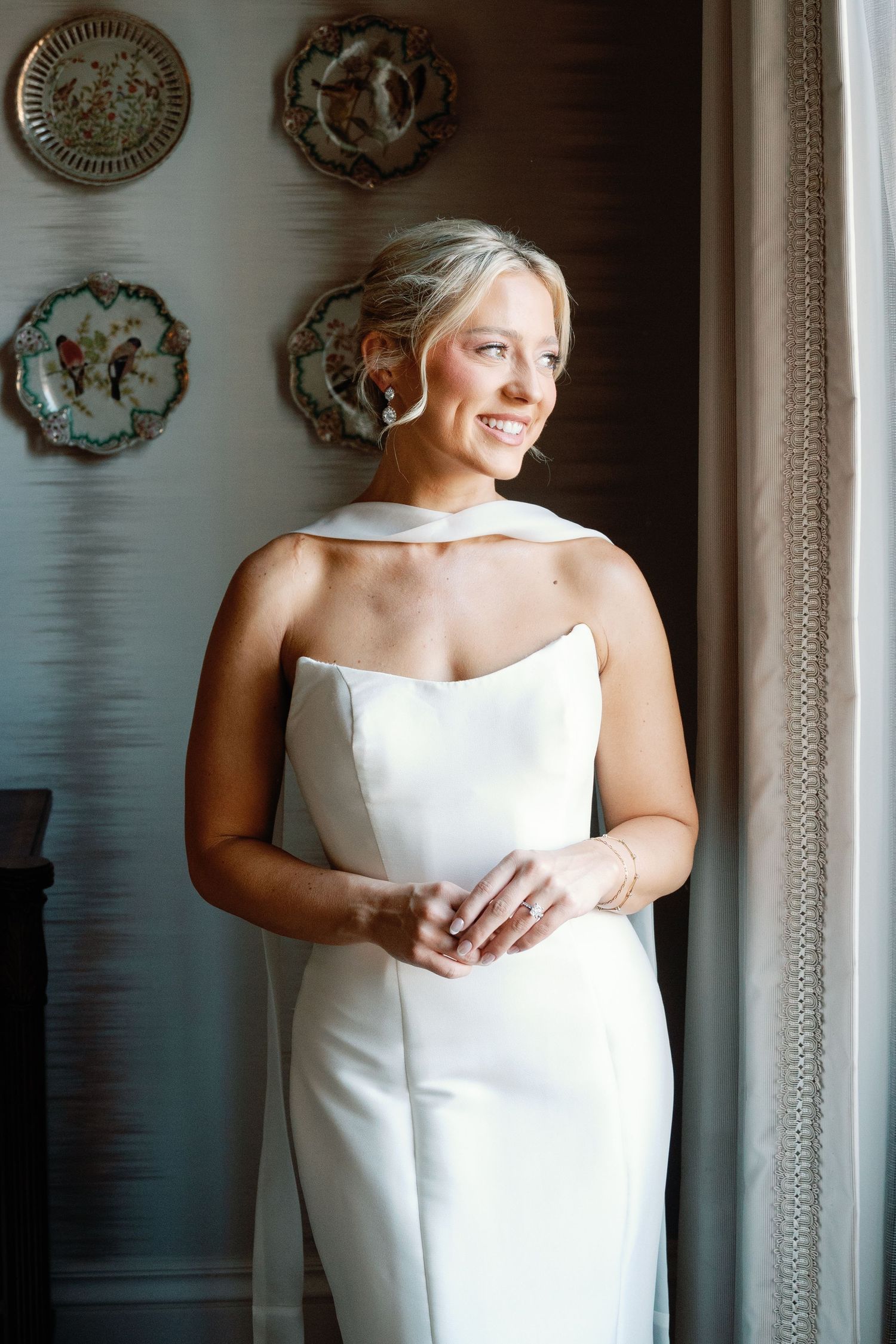 Classic bridal portrait series showing elegant white wedding dress against decorative wall.