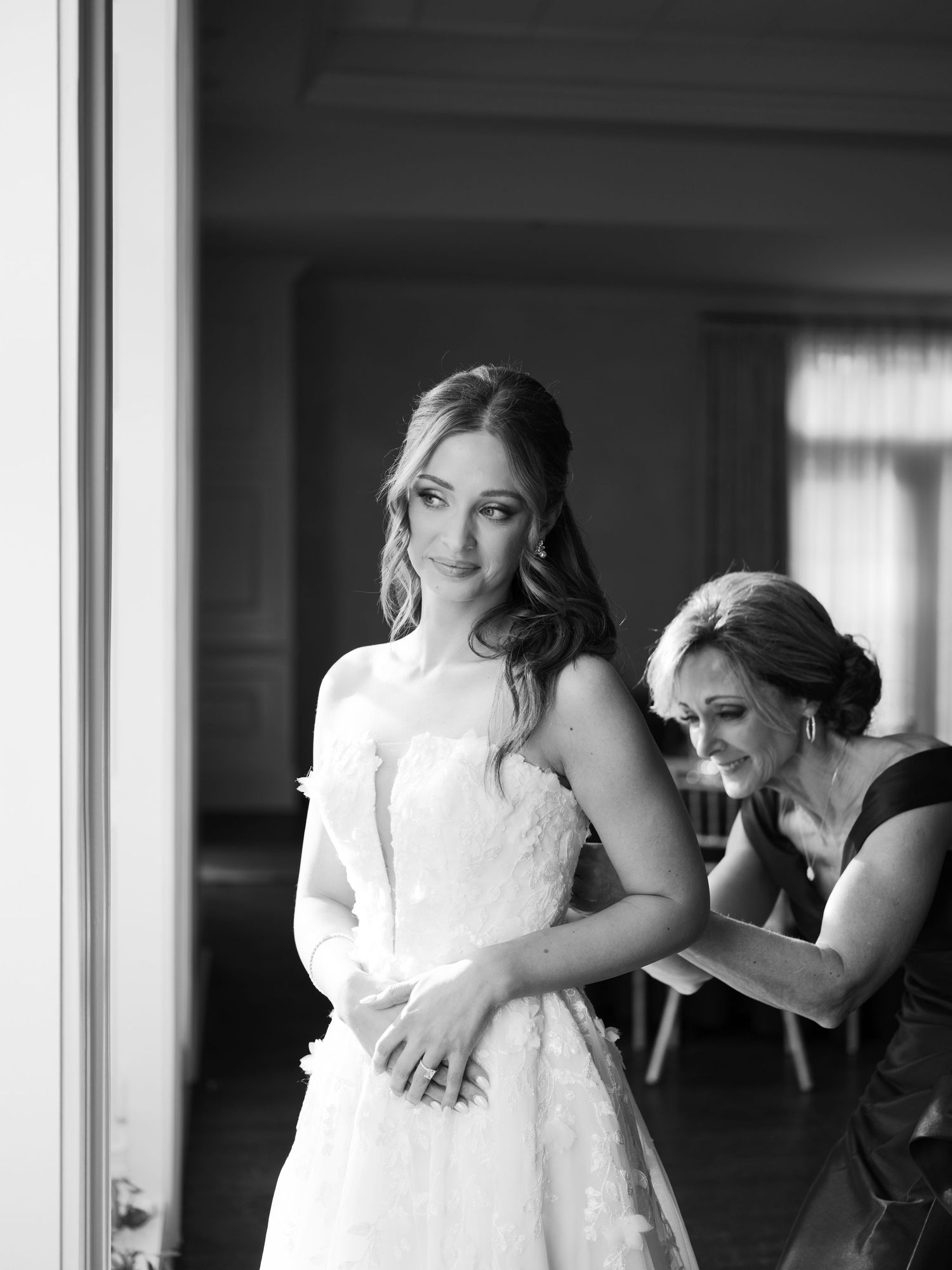 Wedding party shares emotional moment in sunlit room.