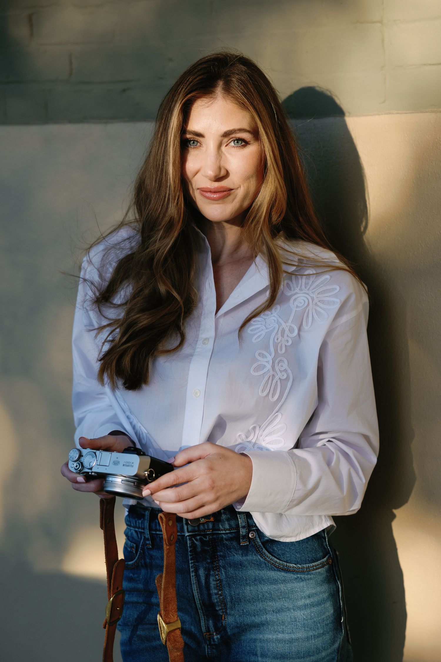 A series of fashion portraits showing a white blouse with embroidered details paired with blue jeans in natural lighting.