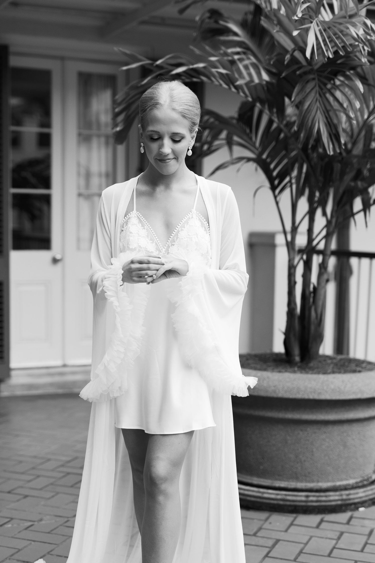 A series of black and white portraits showing a person in white clothing against a light architectural background.
