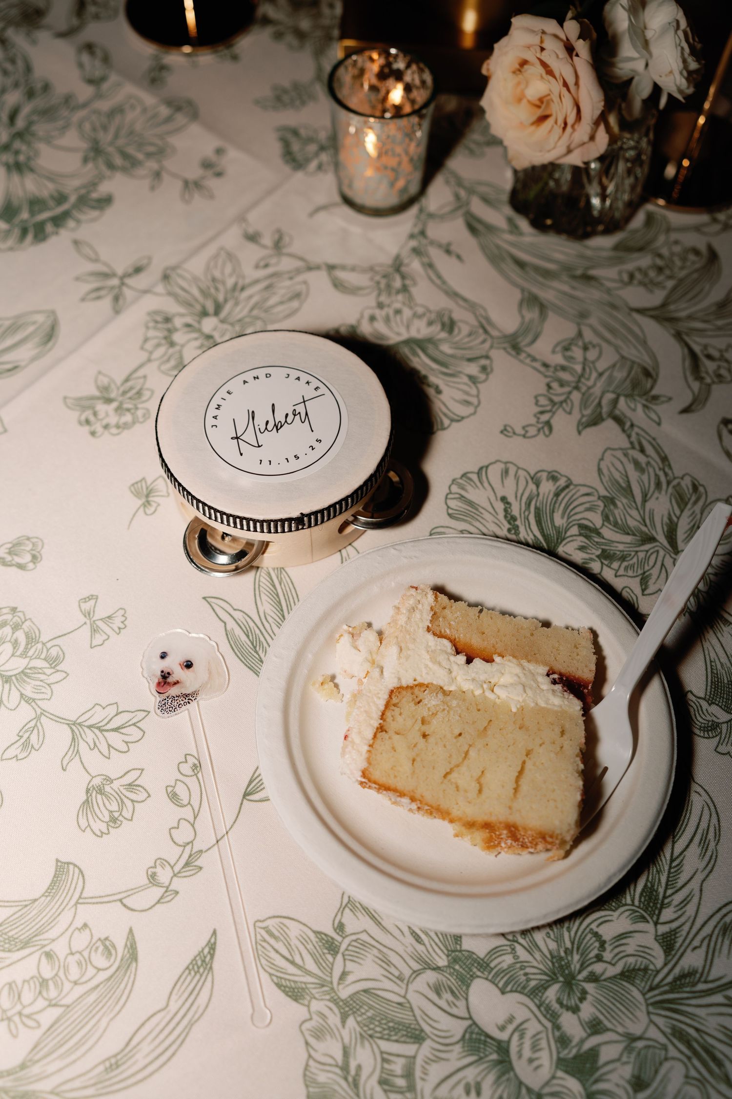 Slices of wedding cake on white plates with floral patterned tablecloth.