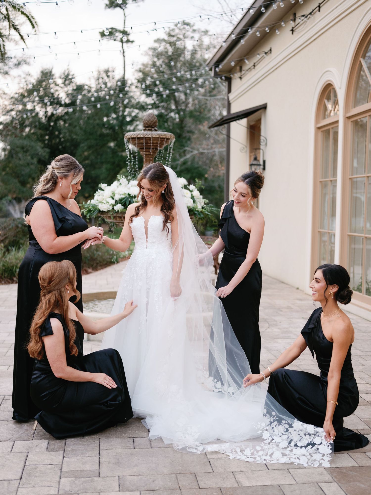 A series of candid wedding preparation moments showing bridesmaids in black dresses helping with a white lace wedding gown.