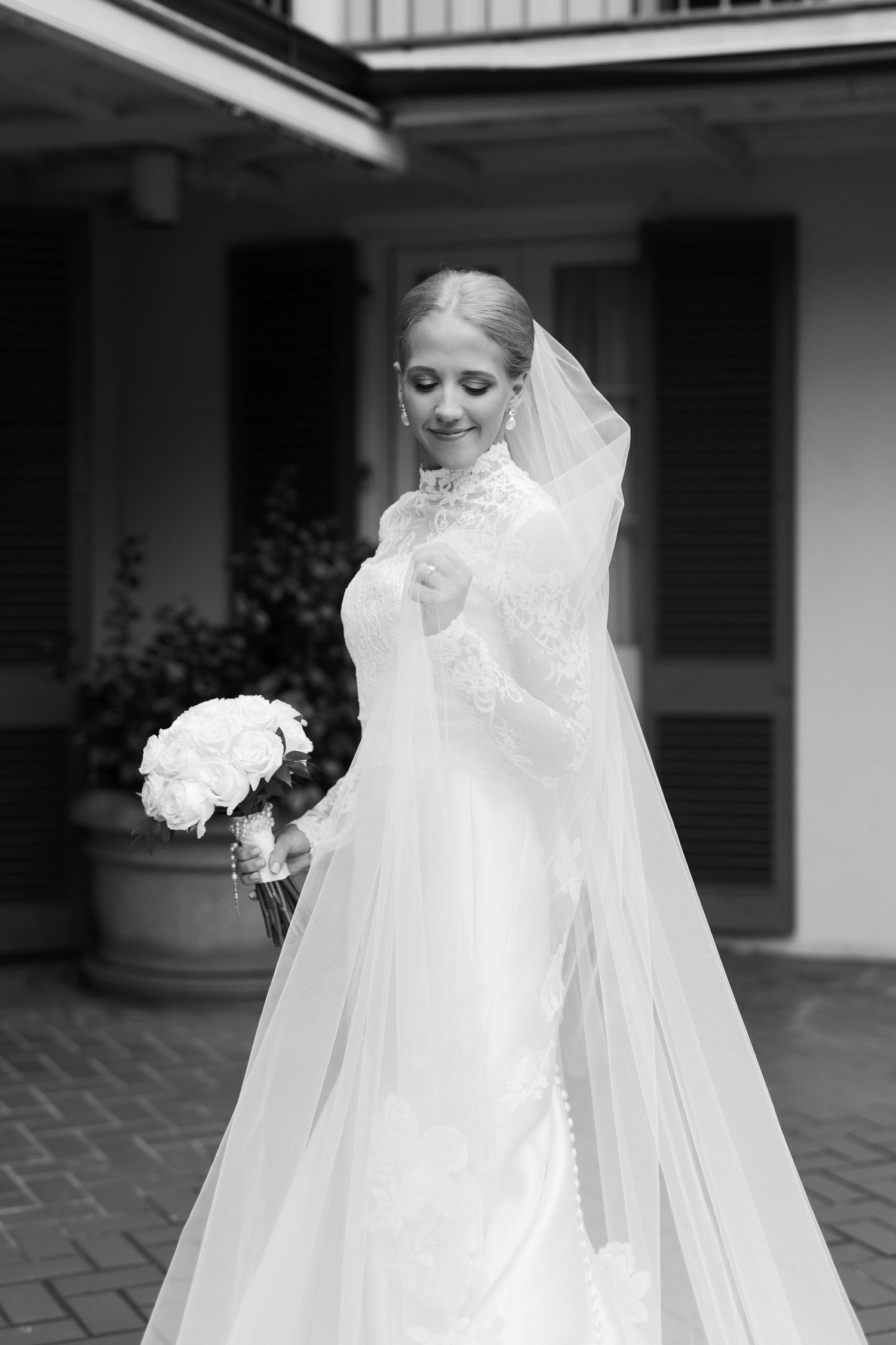 Dramatic black and white photo of a flowing wedding dress with cathedral veil.