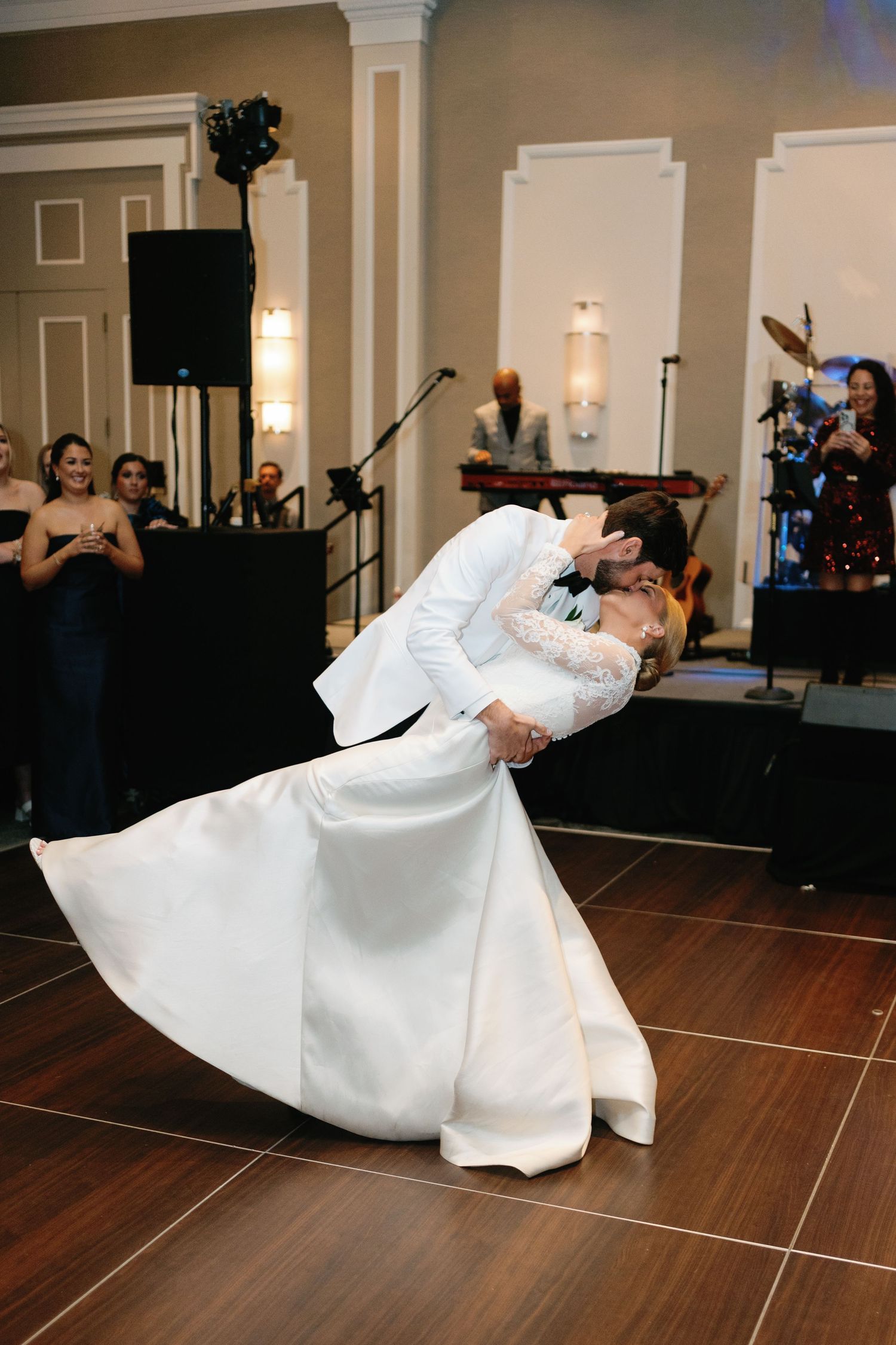 A wedding dance sequence showing a dramatic dip move on a wooden dance floor.