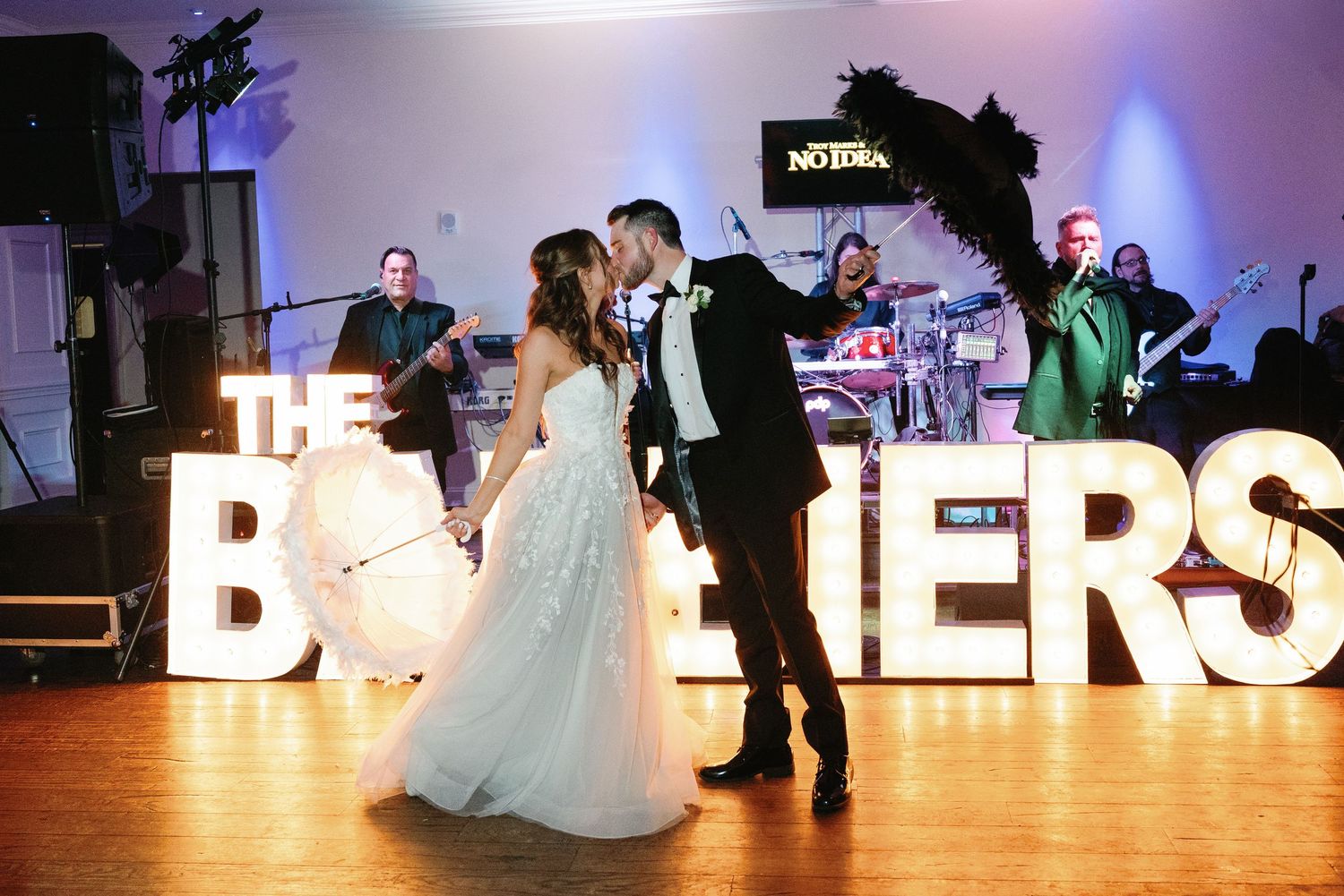 Wedding reception dance floor with illuminated letter decorations and purple lighting.