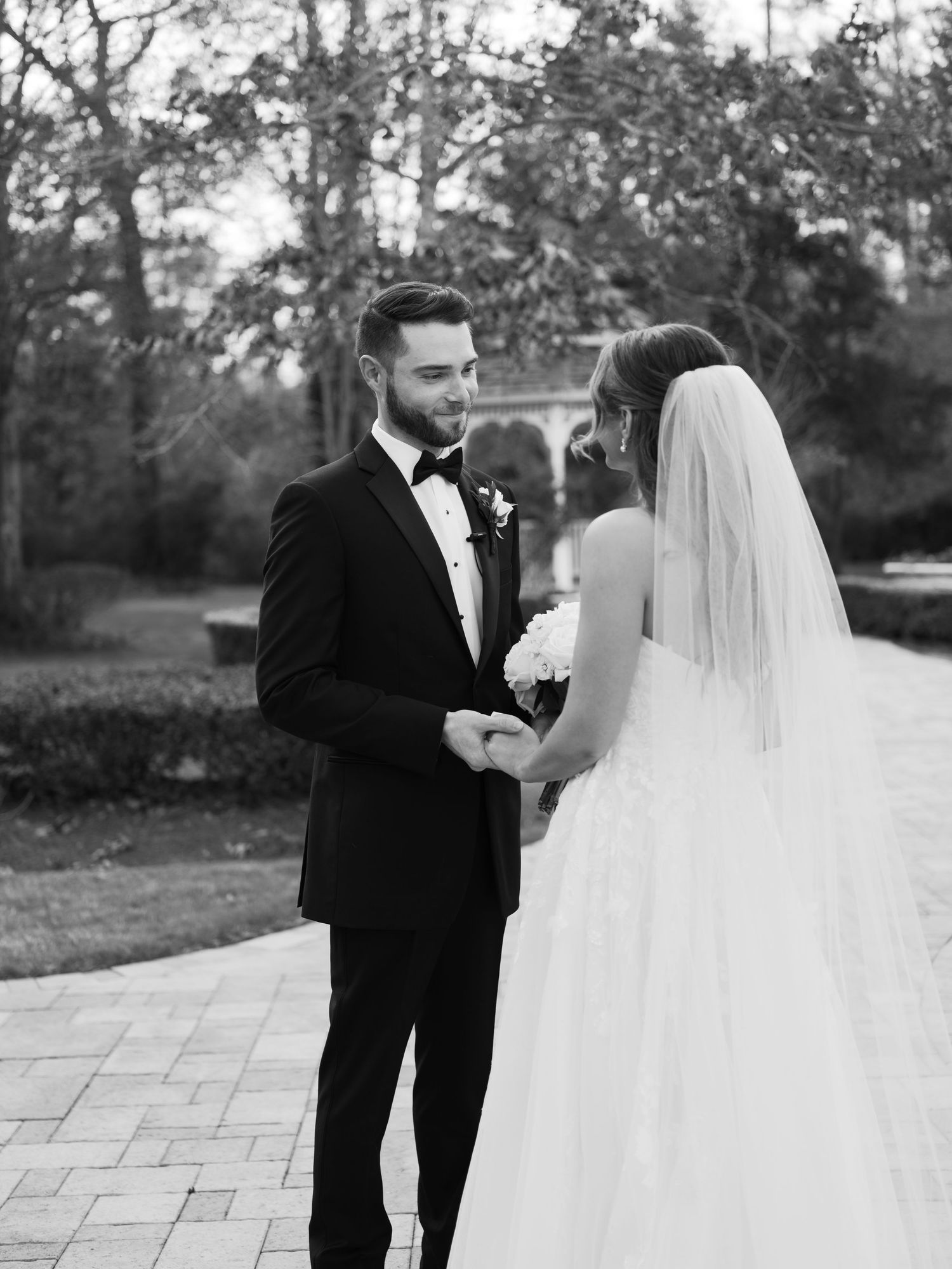 A romantic black and white wedding photo sequence showing a couple walking together on a stone path outdoors.