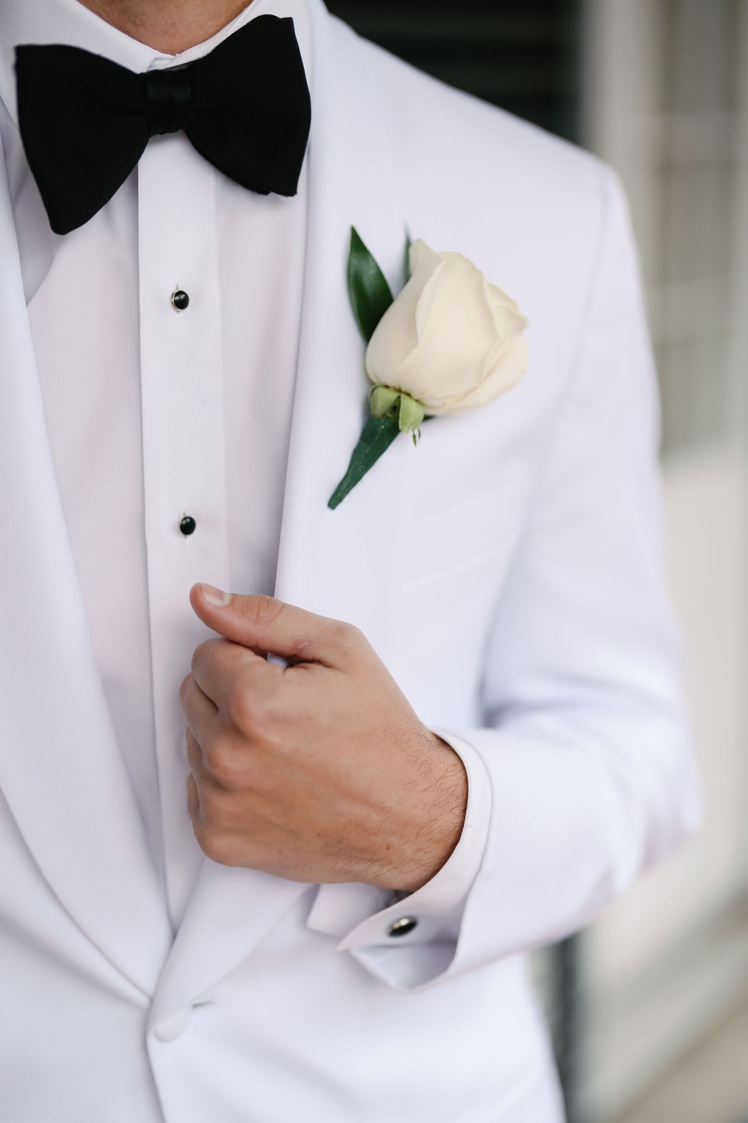 Detail shots of white boutonniere and tuxedo lapel.