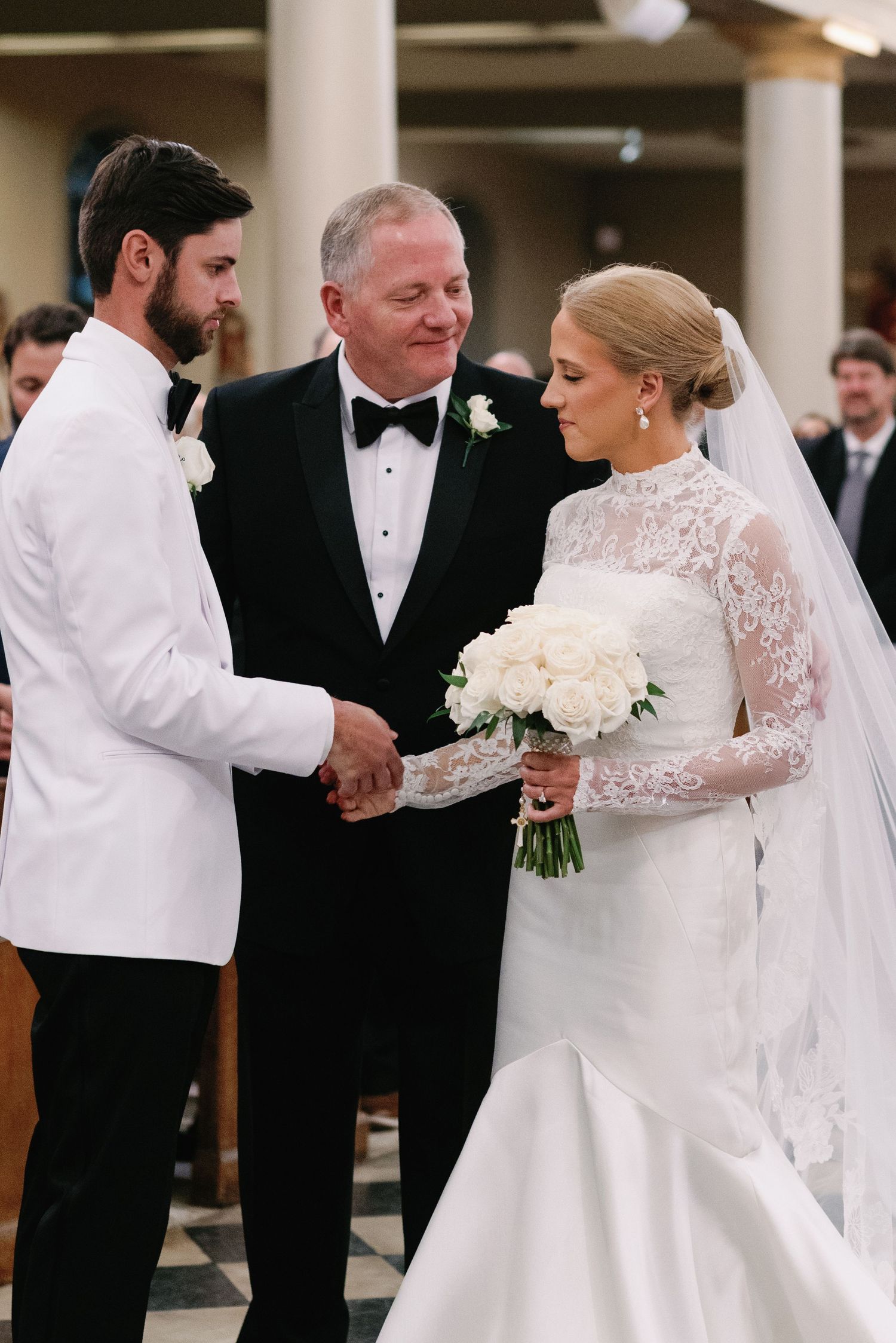 Wedding ceremony moment in church with couple and officiant at altar.