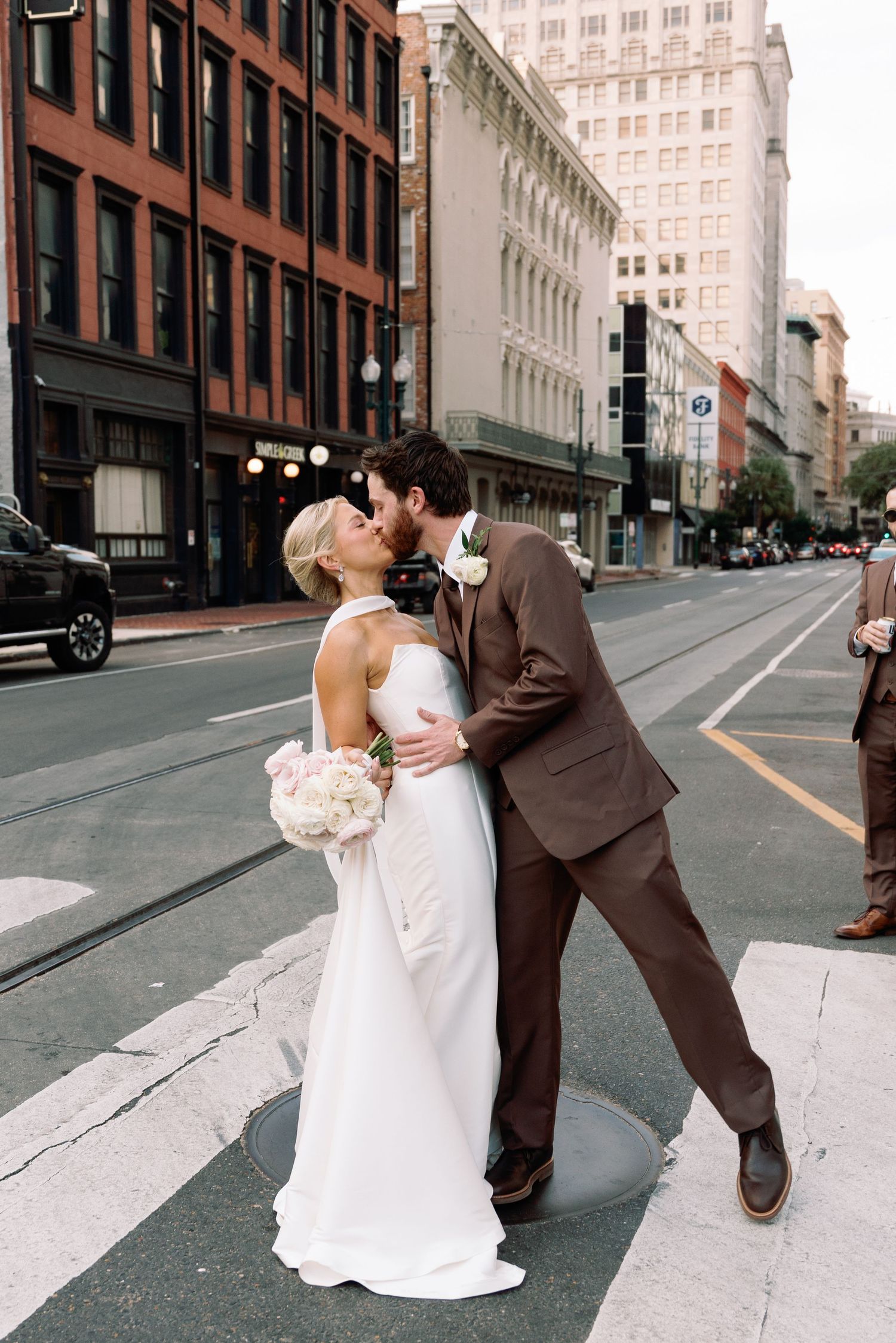 A couple shares a dance-like pose on an urban street.