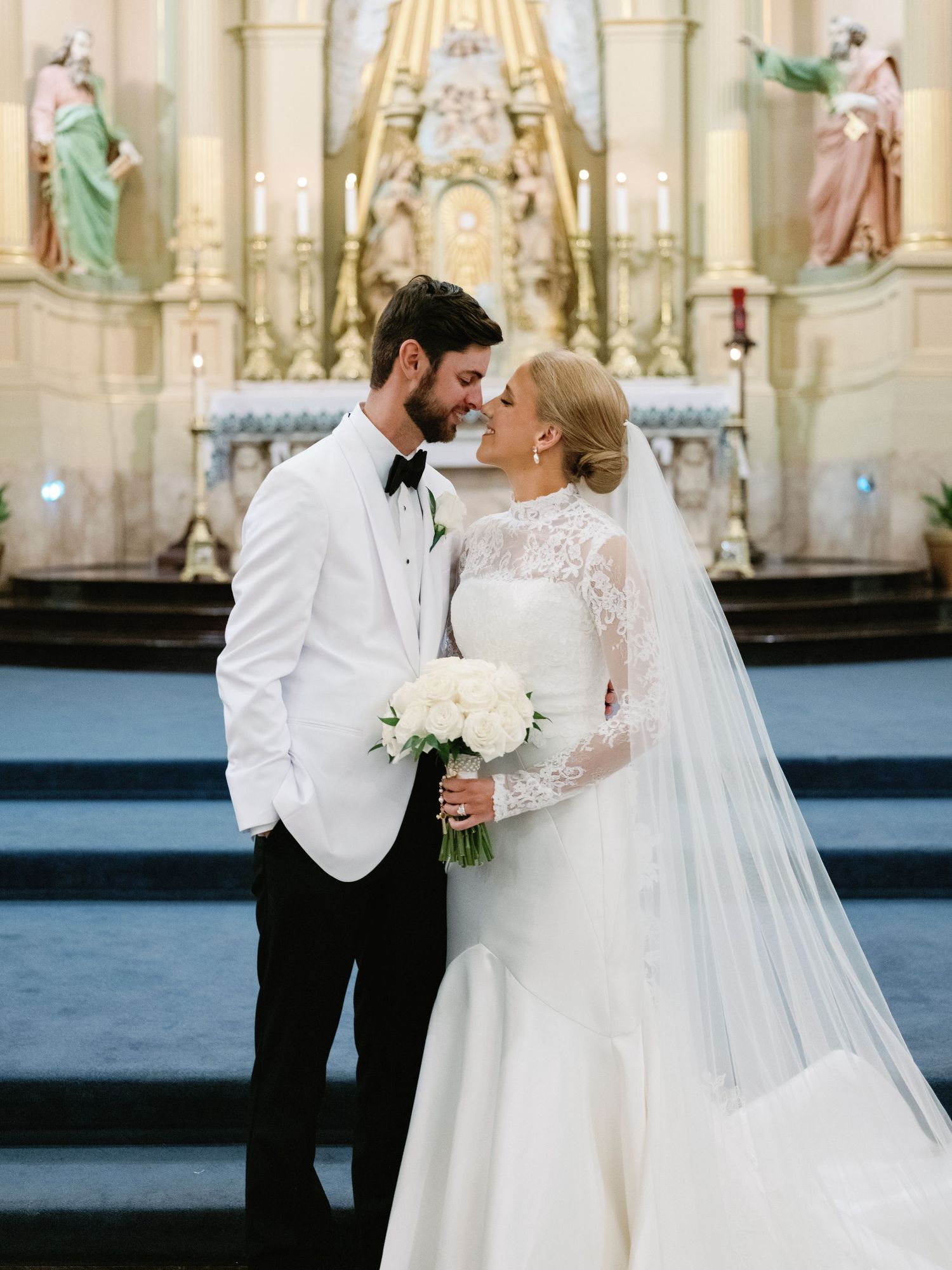 Elegant church wedding ceremony with ornate altar and classical architecture in the background.