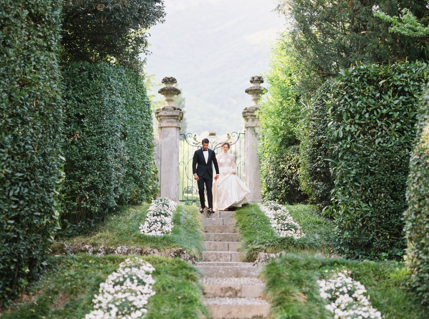 Garden wedding ceremony setup with white flower petals lining a stone pathway.