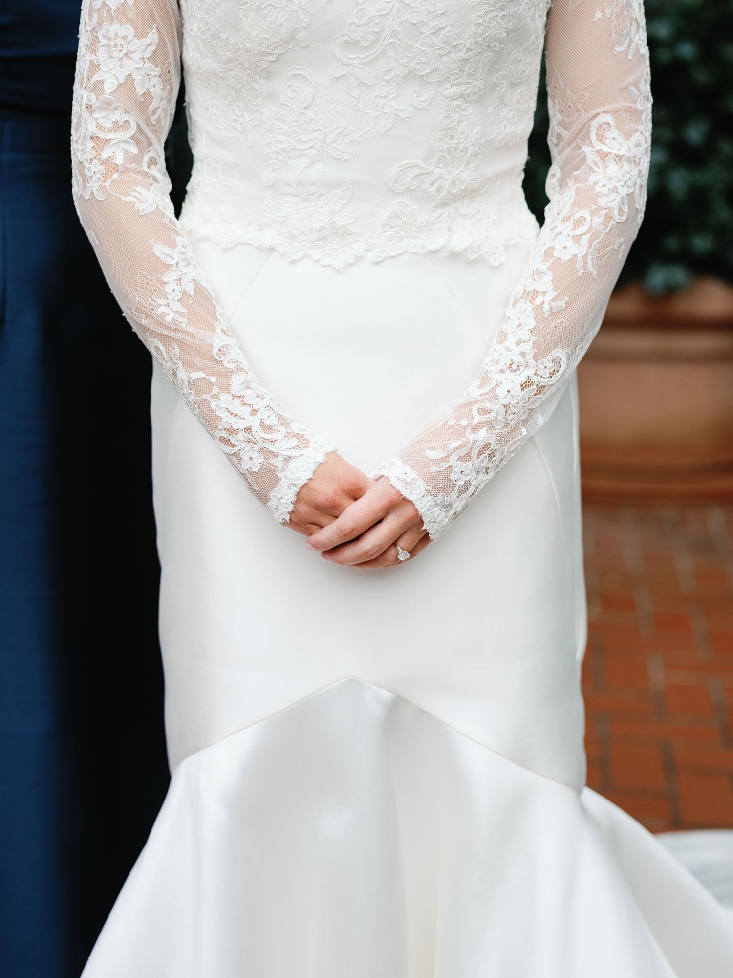 Close-up detail of delicate lace sleeves on an elegant white wedding gown.