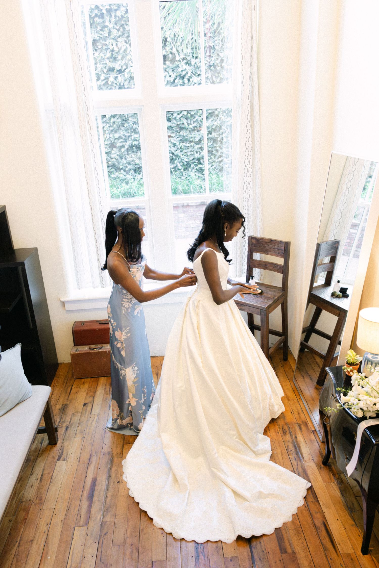 Sydney's sister buttons up the back of her wedding dress at 701 Whaley in Columbia, SC.