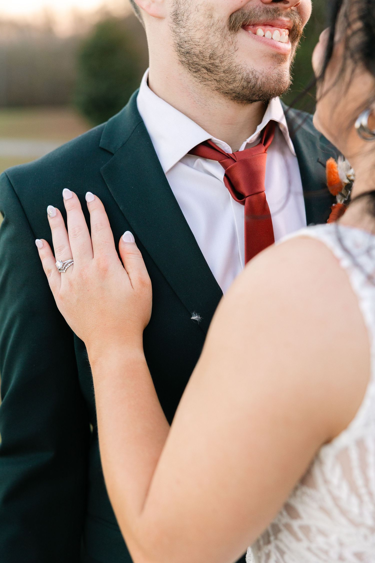A detail photo of a bride's wedding rings on the grooms chest.