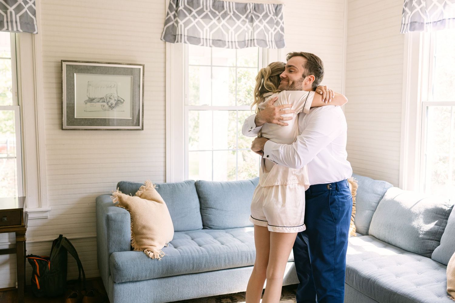 A groom hugs a bridesmaid after she delivered a note from the bride on his wedding day at The Corley Mill House in Columbia, SC.