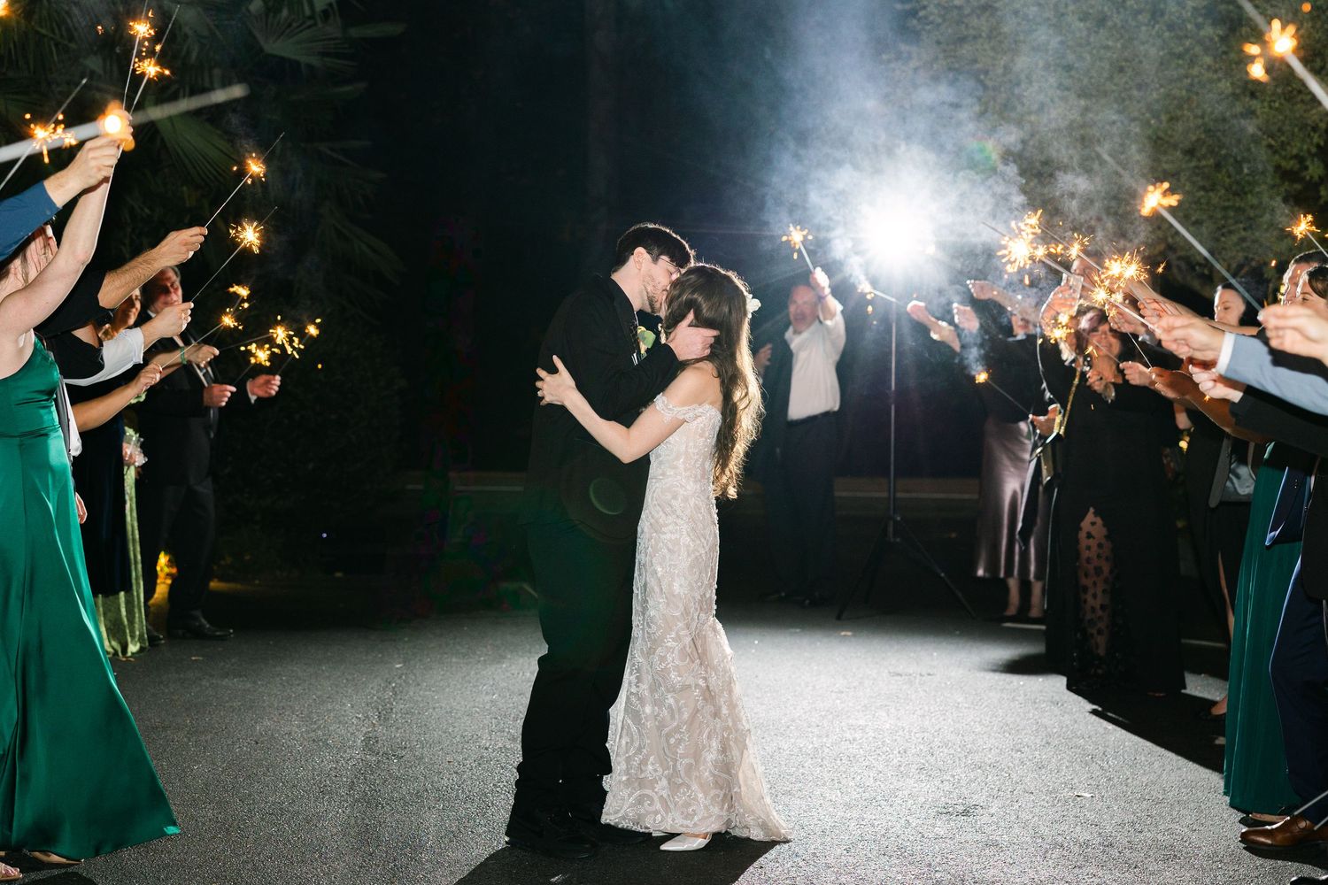 A couple kisses during their sparkler exit at The River Road and Jasmine House & Gardens in Columbia, SC.