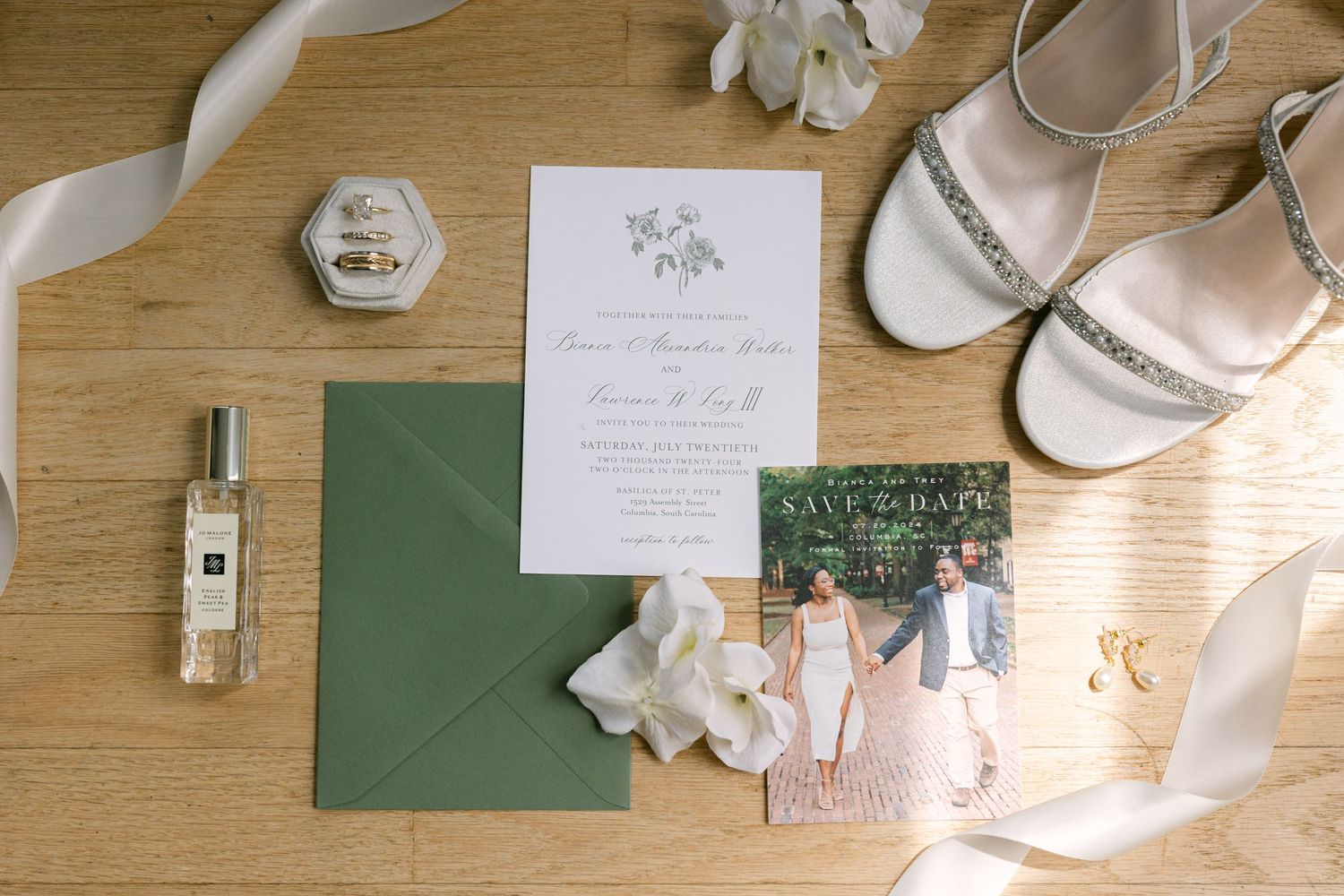 Wedding day details (invitations, dress, shoes, rings, perfume, etc.) arranged nicely for a flat lay.