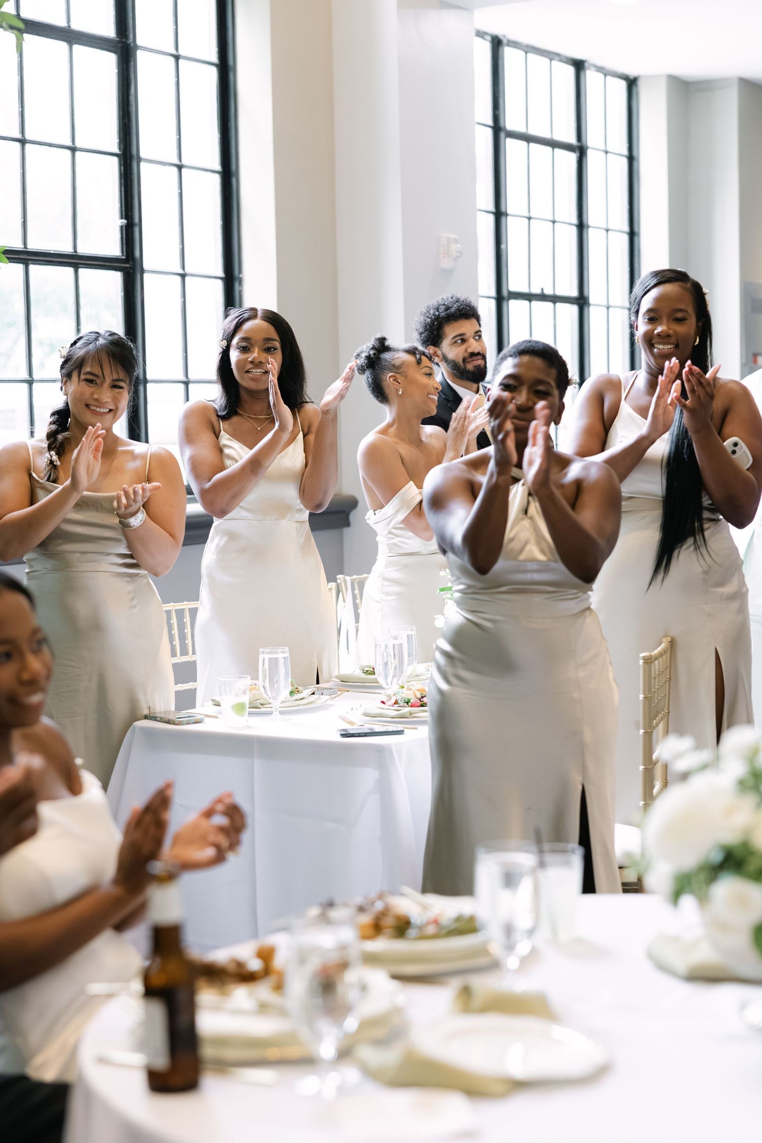 A wedding party stands and claps for the bride and groom on their wedding day at 1208 Washington Place in Columbia, SC.