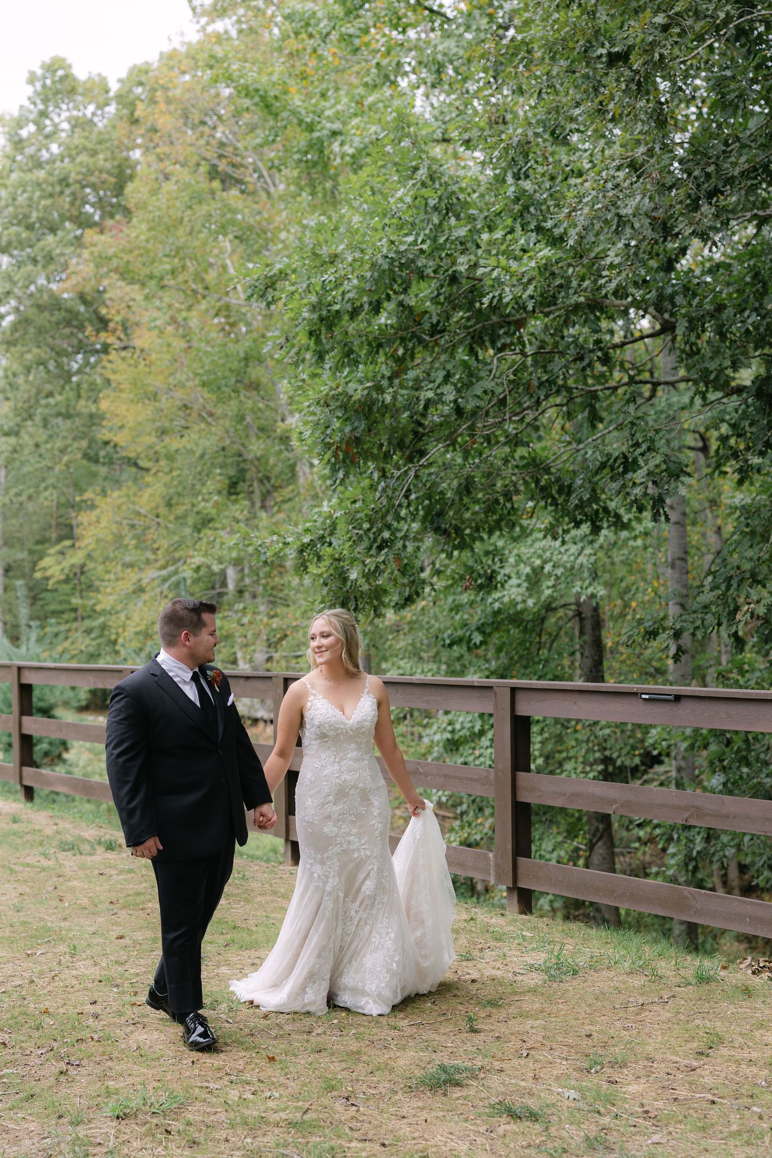 A couple walks along a pathway at Piney Grove Ranch in South Carolina on their wedding day.