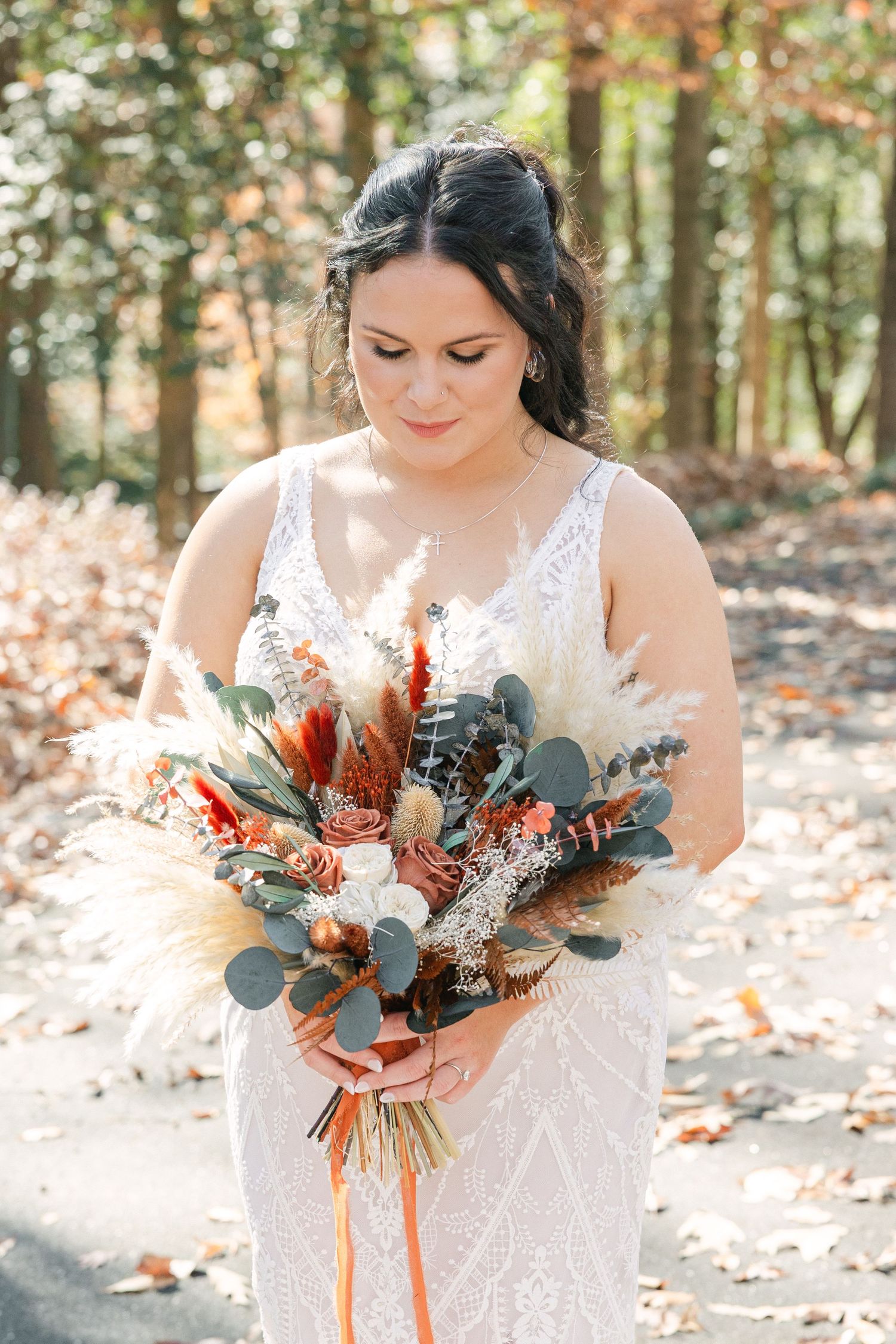 A bride looks at her flowers on her wedding day in the South Carolina Upstate.