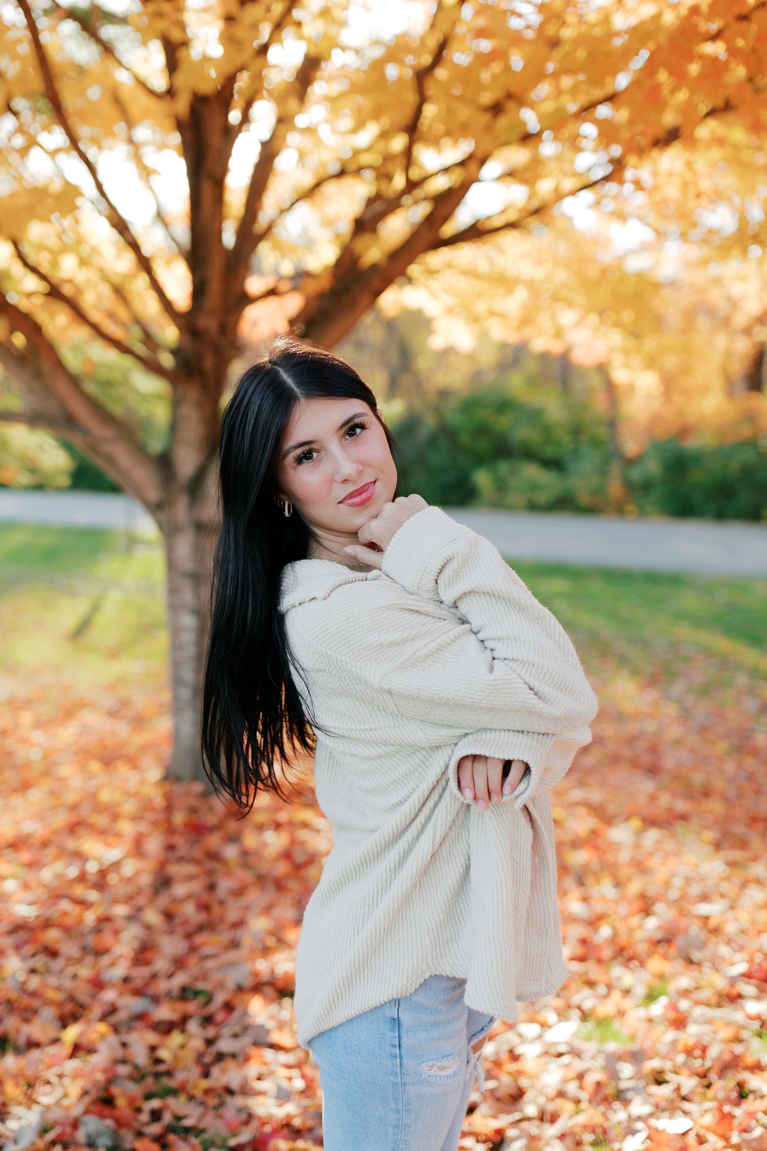 Casual fall fashion poses among fallen leaves and autumn trees.