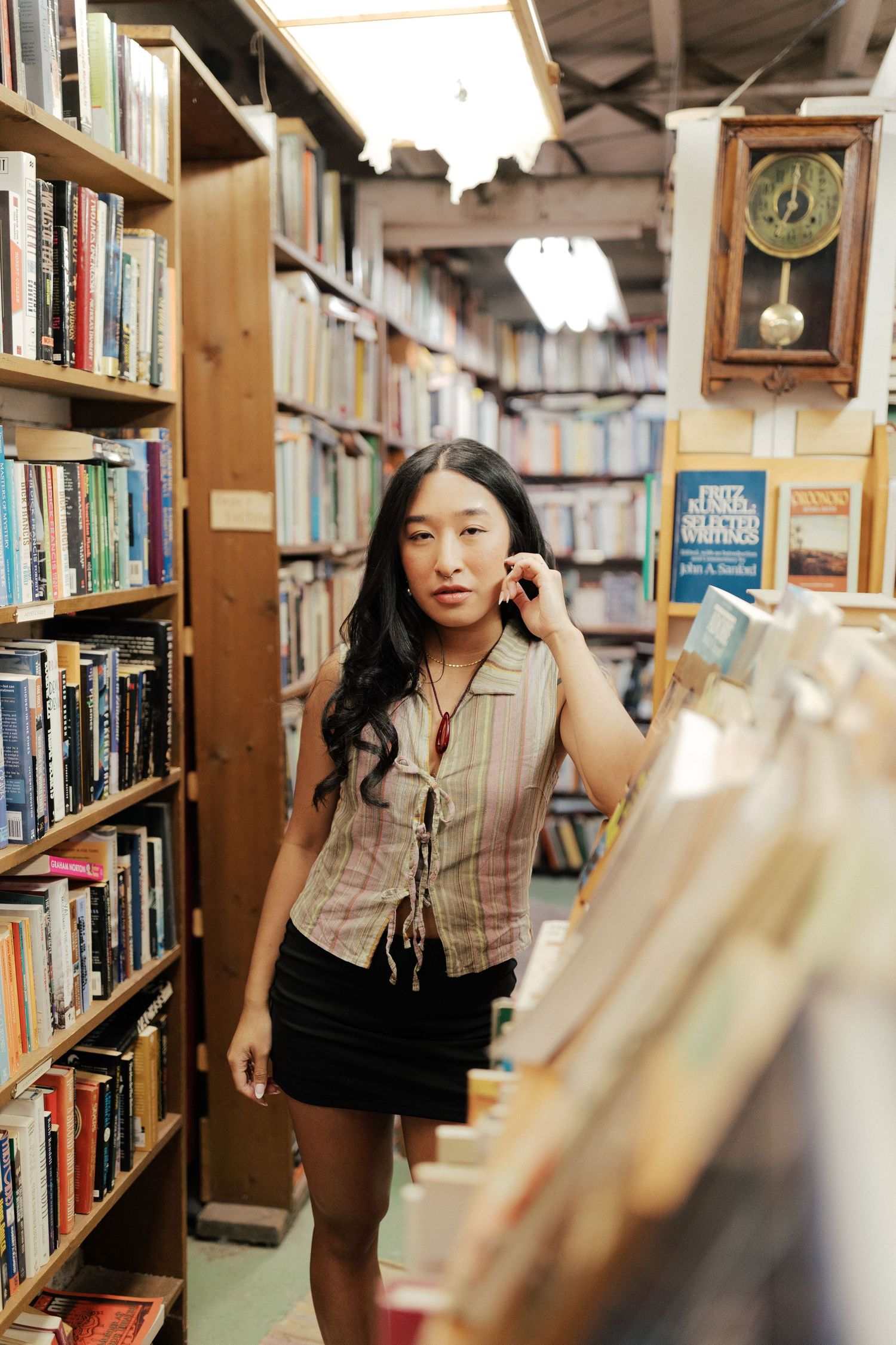 Portrait session in a library with bookshelves creating a cozy academic atmosphere.