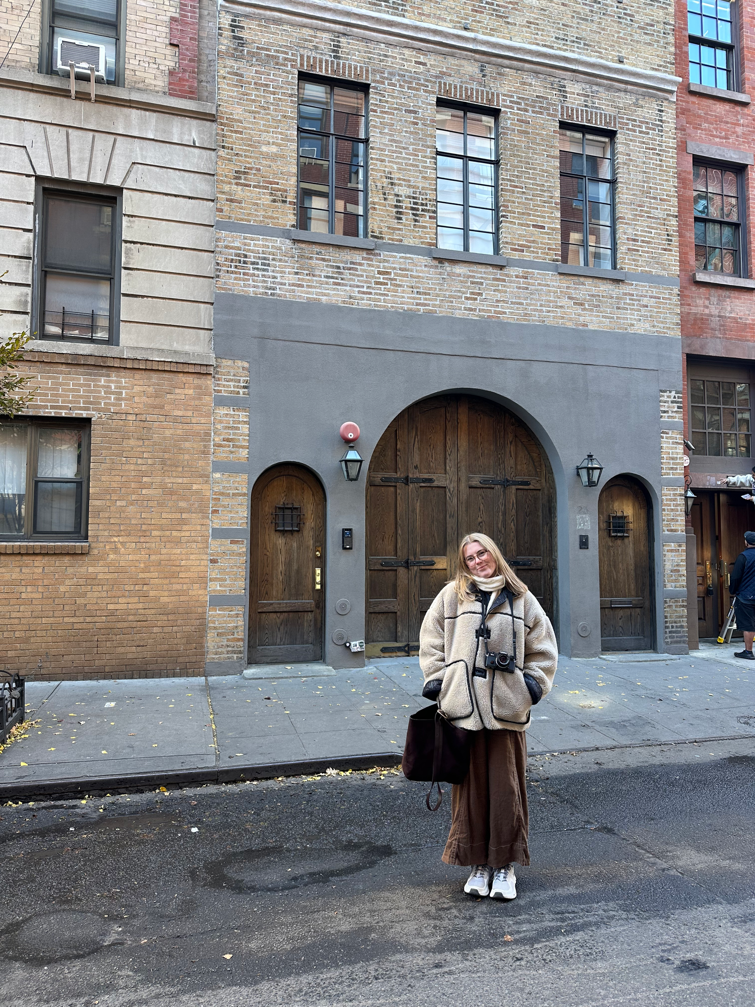 Urban street scene with brick buildings and arched doorways in sequence.